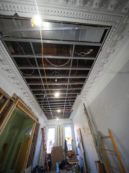 Interior hallway under renovation with exposed ceiling and wiring