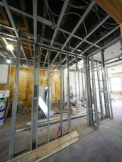 Interior construction with metal studs and exposed wiring.