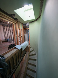 Interior hallway under renovation with spiral staircase and skylight.