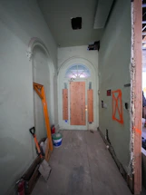 Hallway with boarded-up door and construction materials