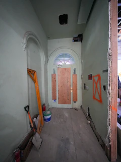 Hallway with boarded-up door and construction materials