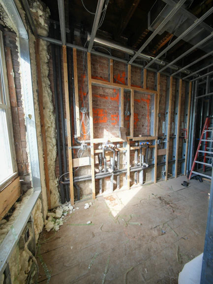 Interior construction with exposed pipes and framing