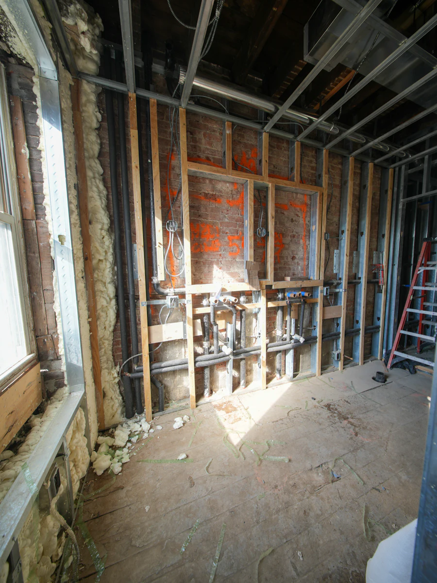 Interior wall opened to expose plumbing during water damage repair