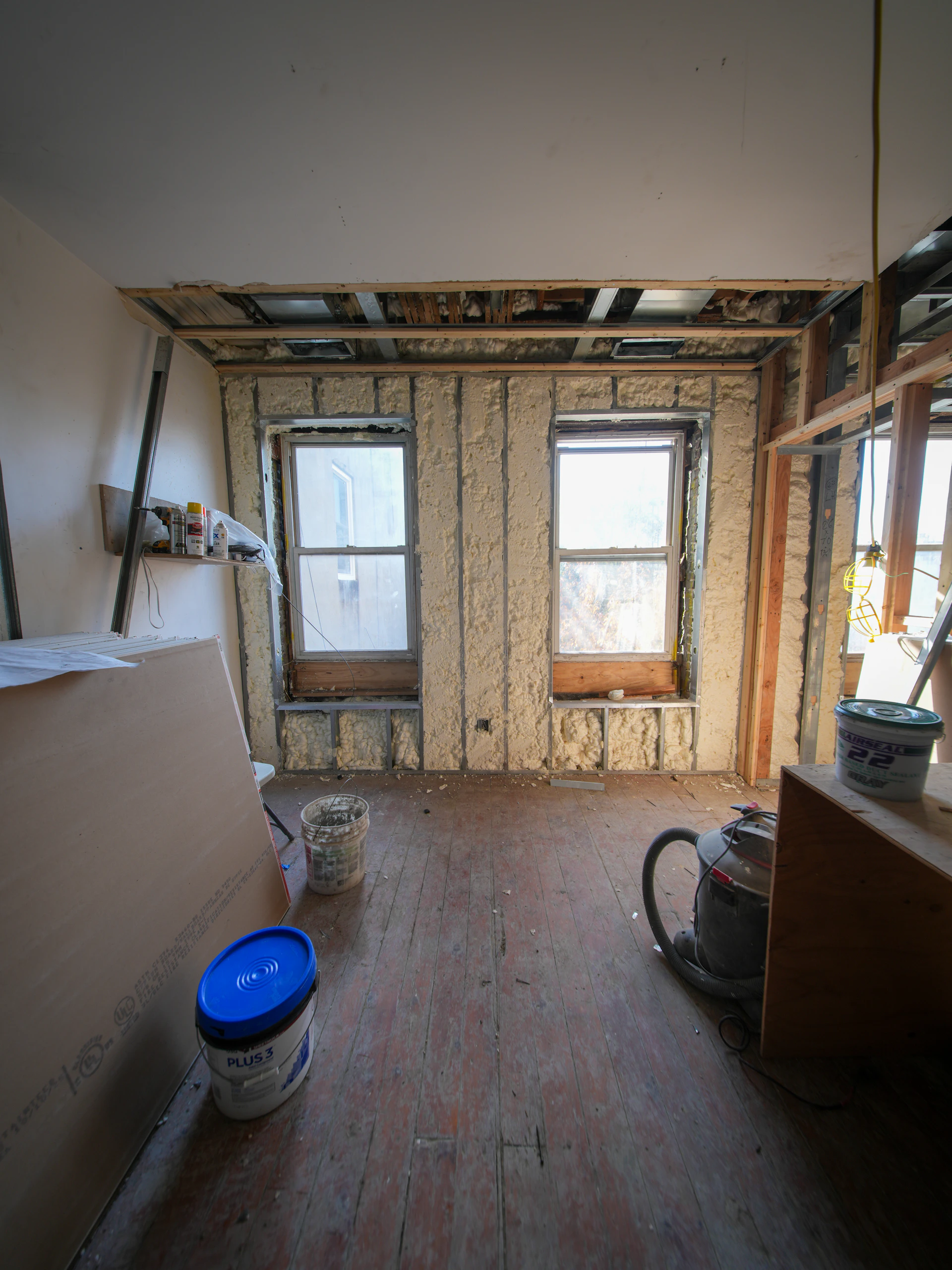 Room under construction with exposed walls and windows.