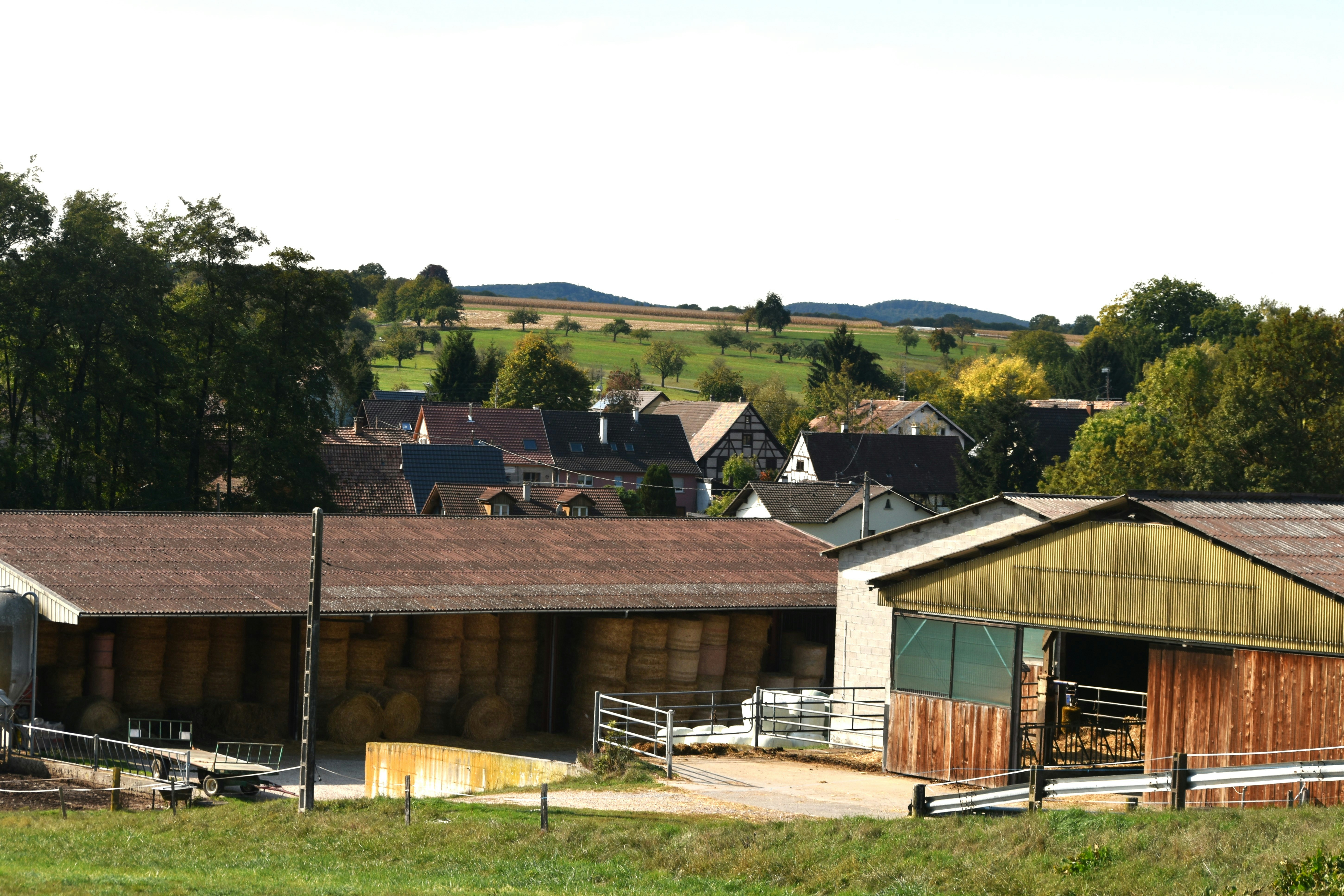 Bauernhofgebäude mit einem Dorf im Hintergrund