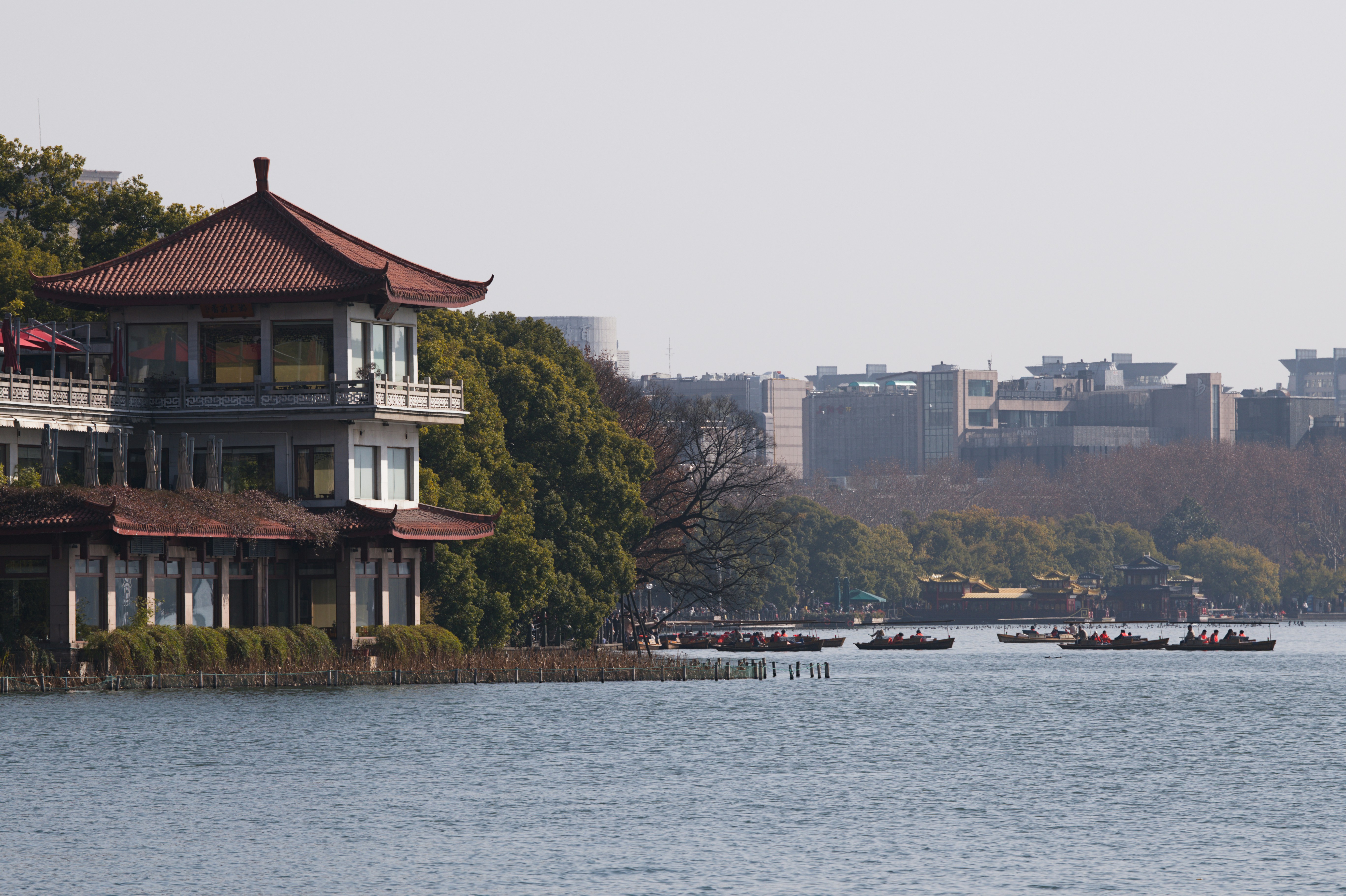 Construcción tradicional junto a un lago con barcos a lo lejos