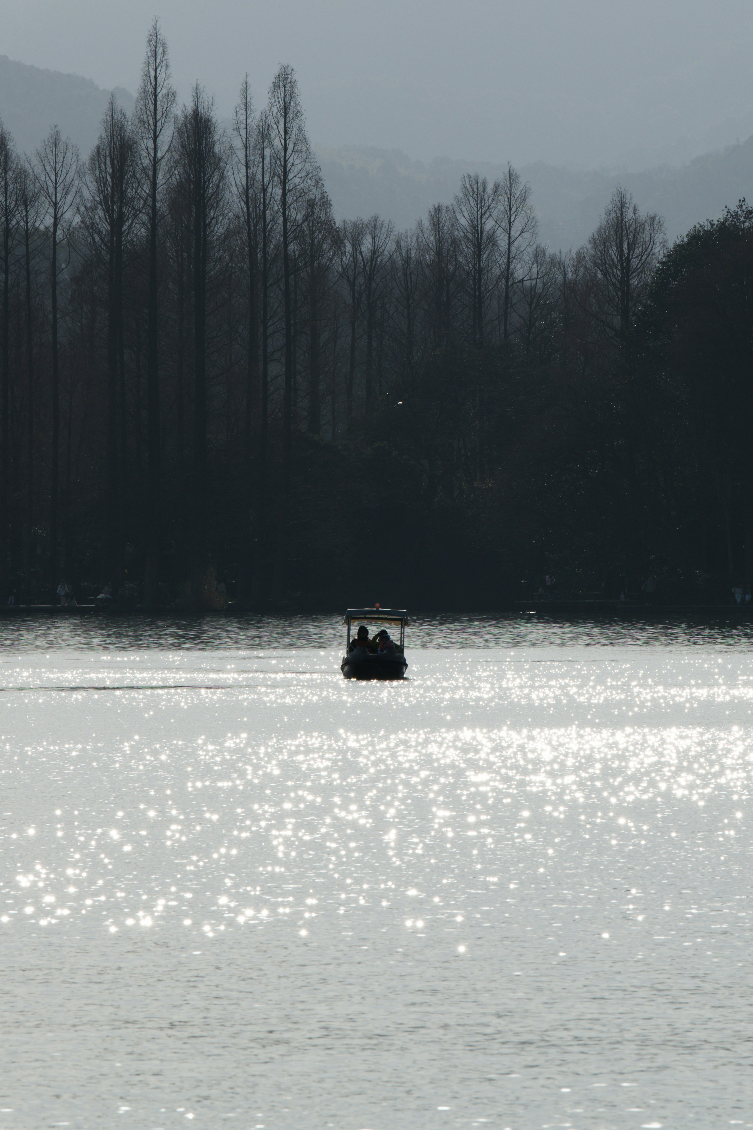 Un pequeño barco cruza un lago brillante.