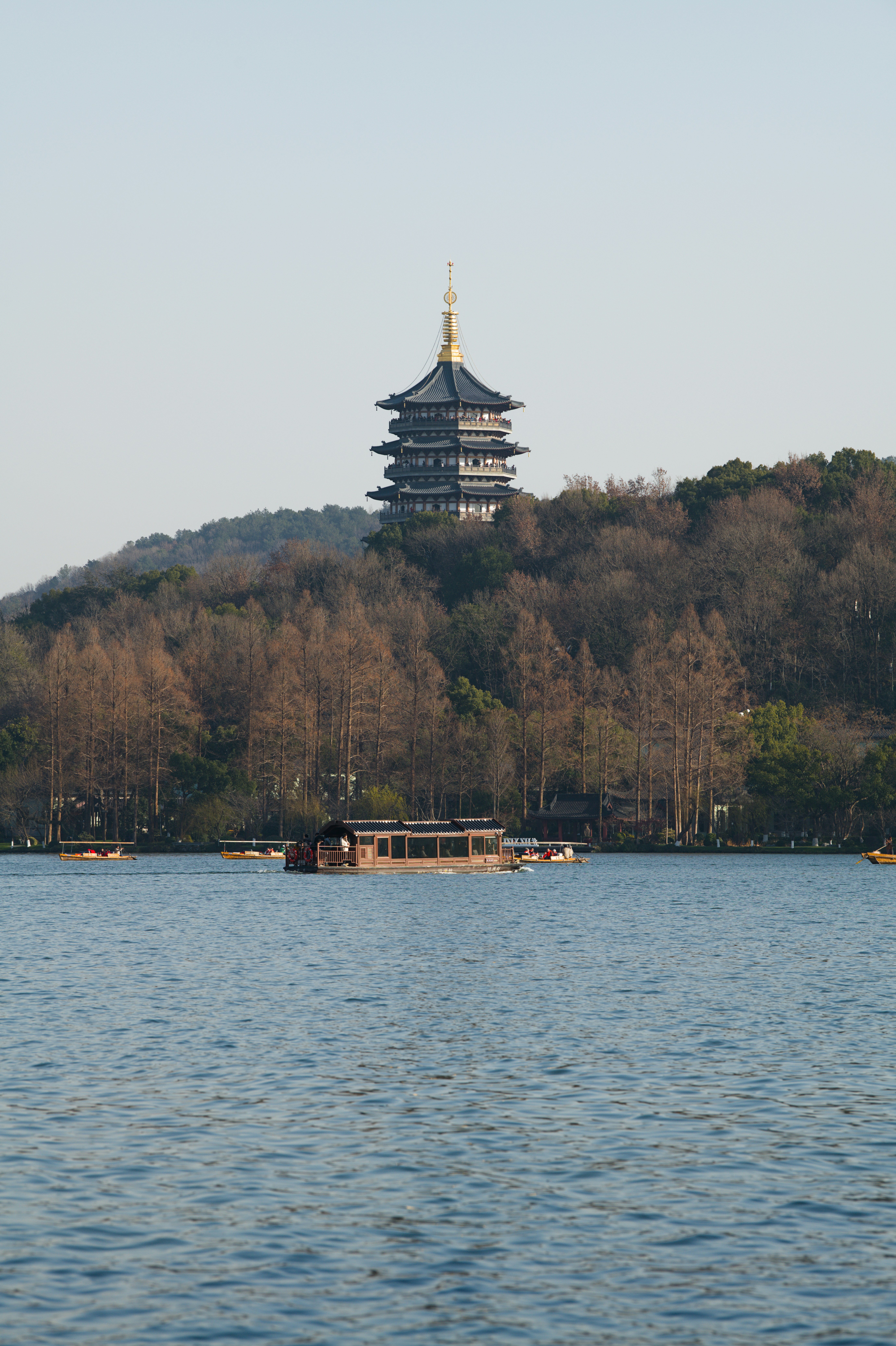 Pagoda en una colina con vistas a un lago tranquilo con barcos