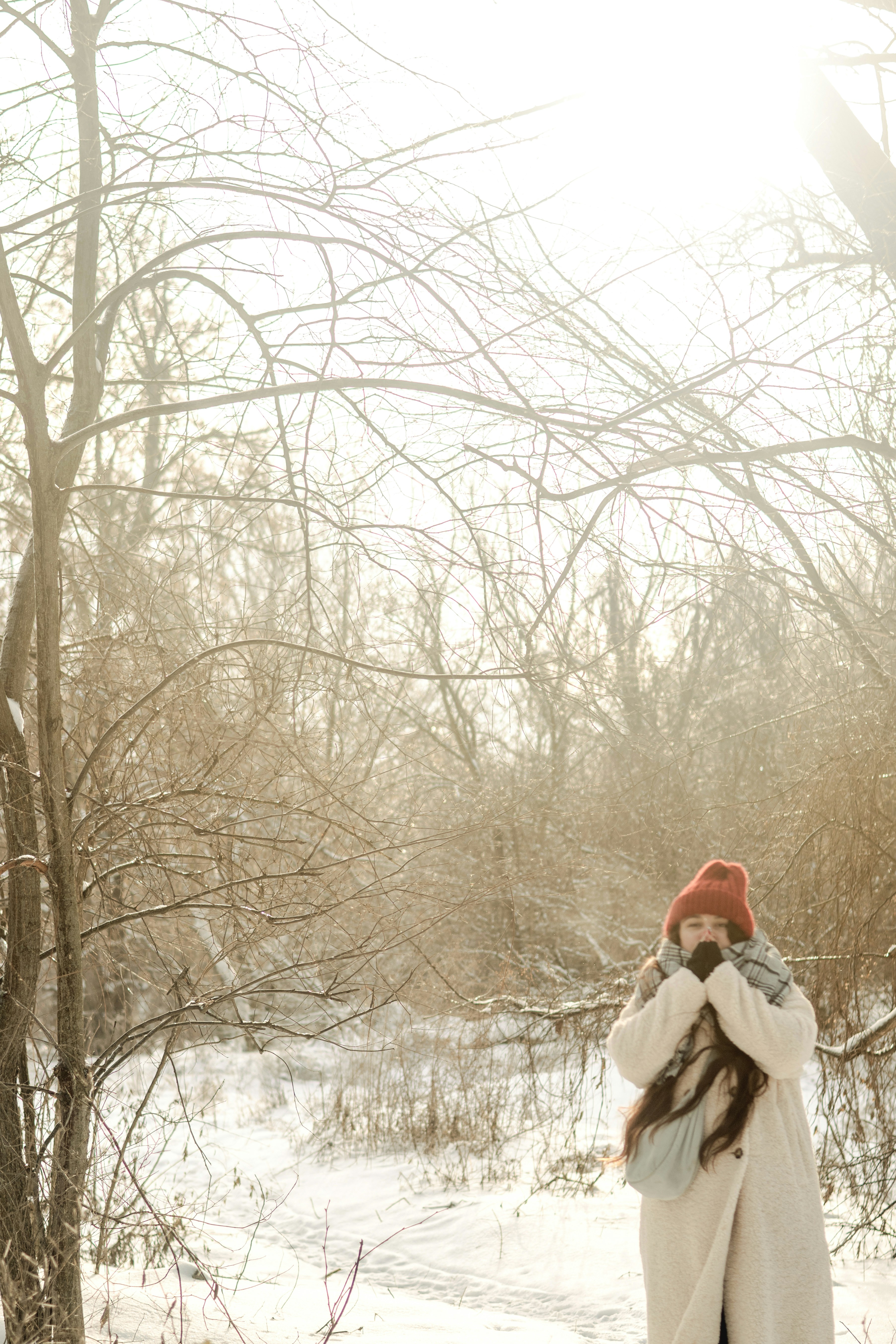 Woman in red hat and scarf in snowy woods