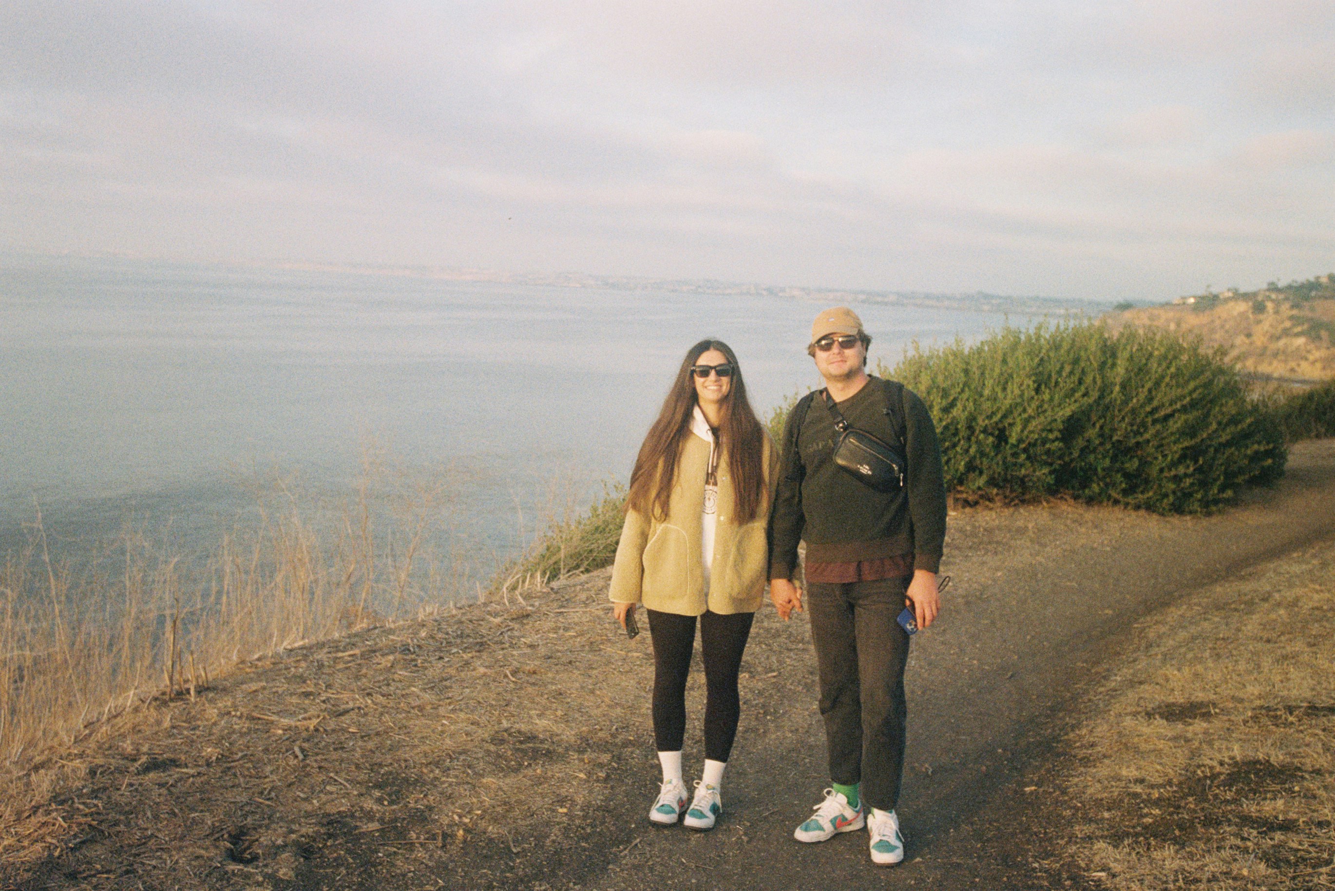 Pareja de pie en un sendero con vistas al océano