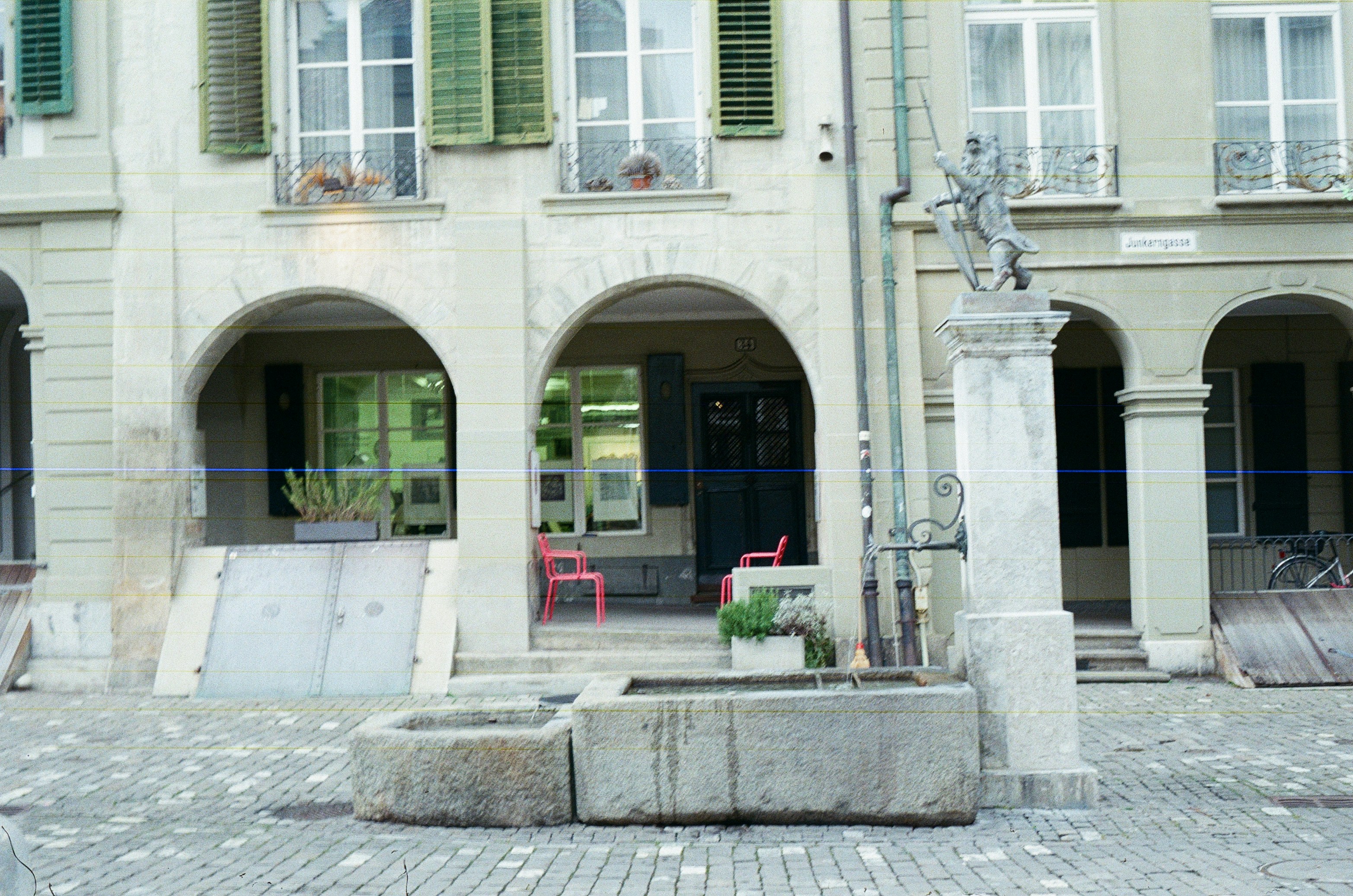 Stone fountain in front of arched building entrance