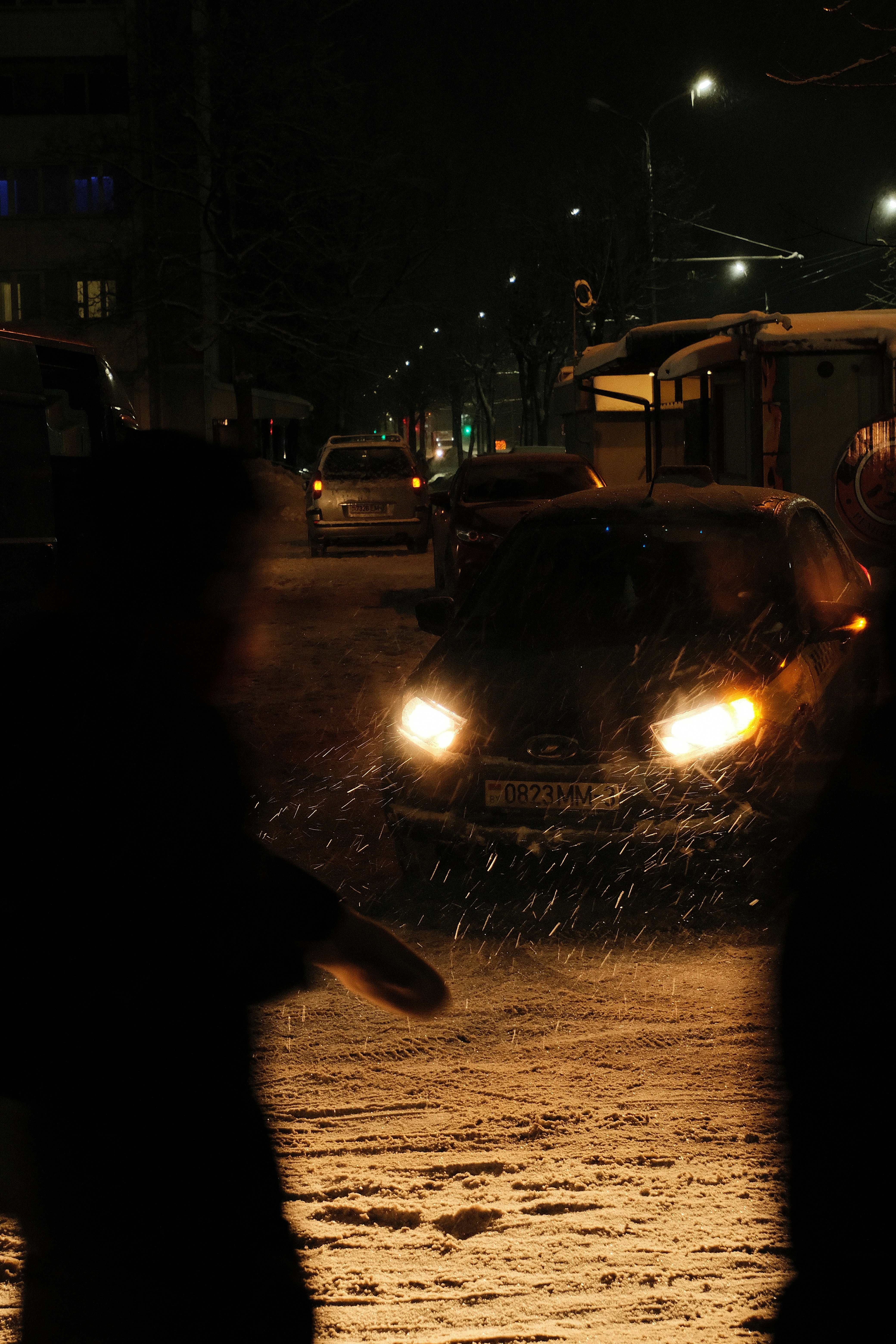Cars driving on a snowy street at night