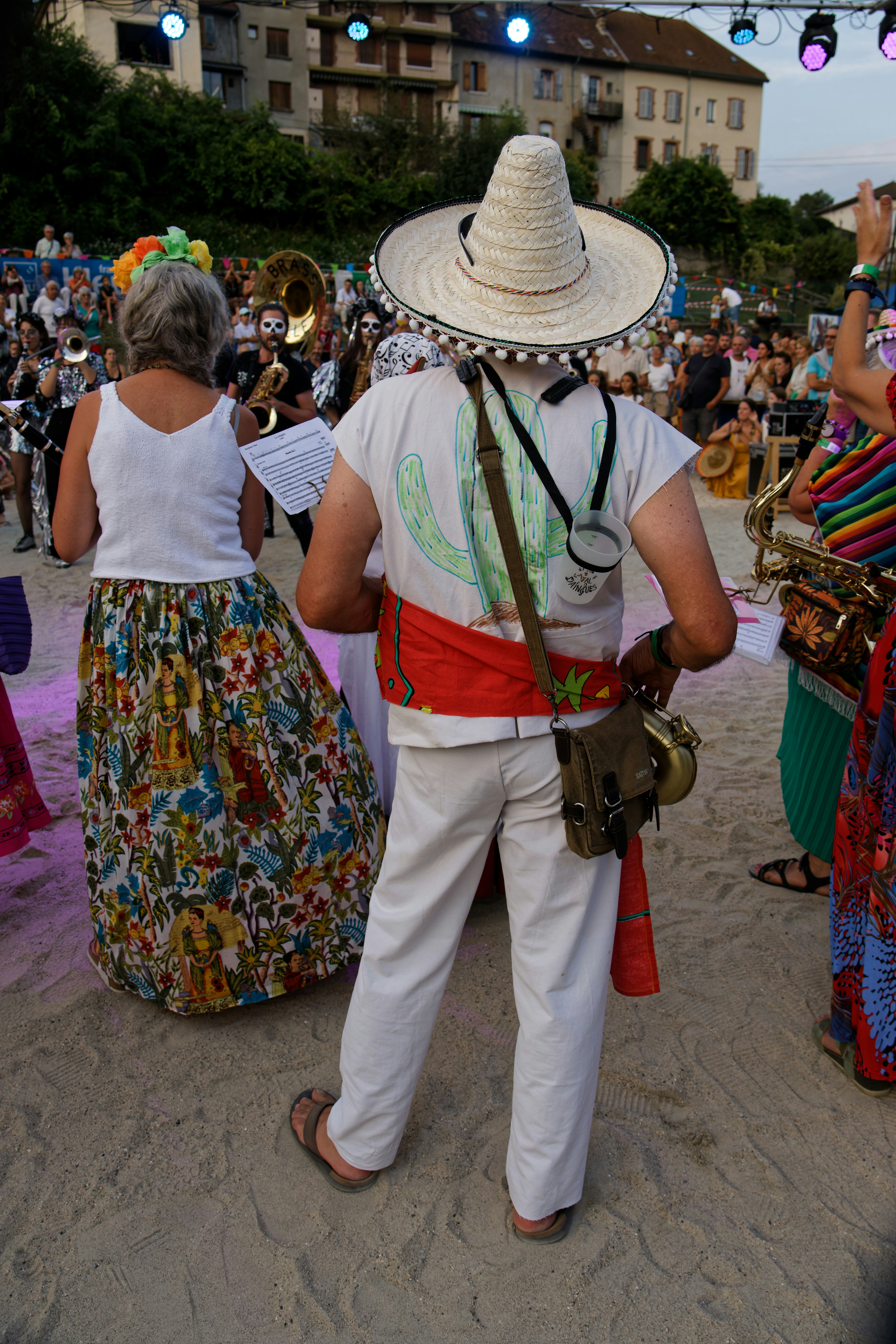 Man in sombrero and colorful sash at outdoor event