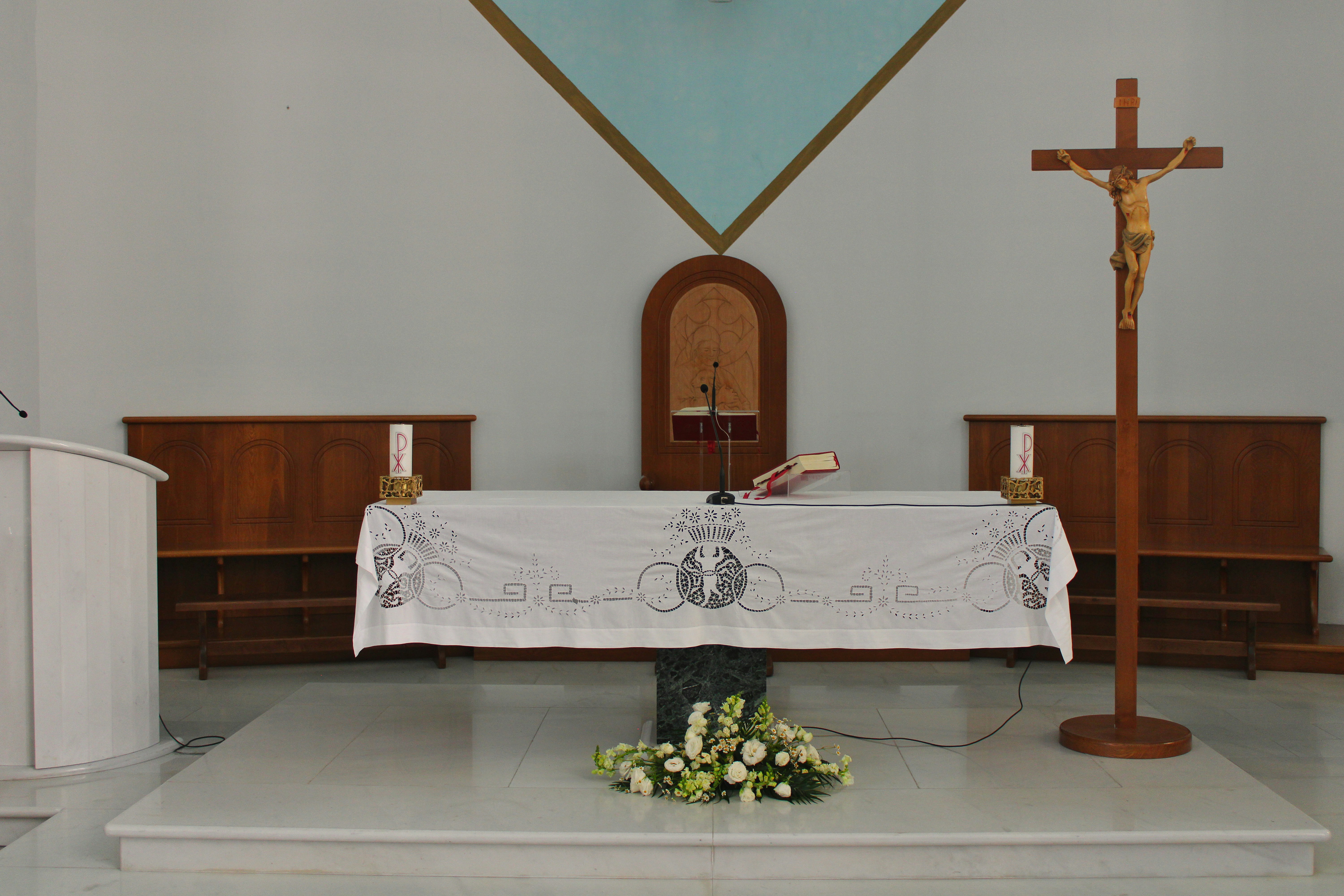Altar with crucifix and floral arrangement in church
