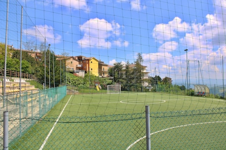 Soccer field with goal and surrounding buildings.