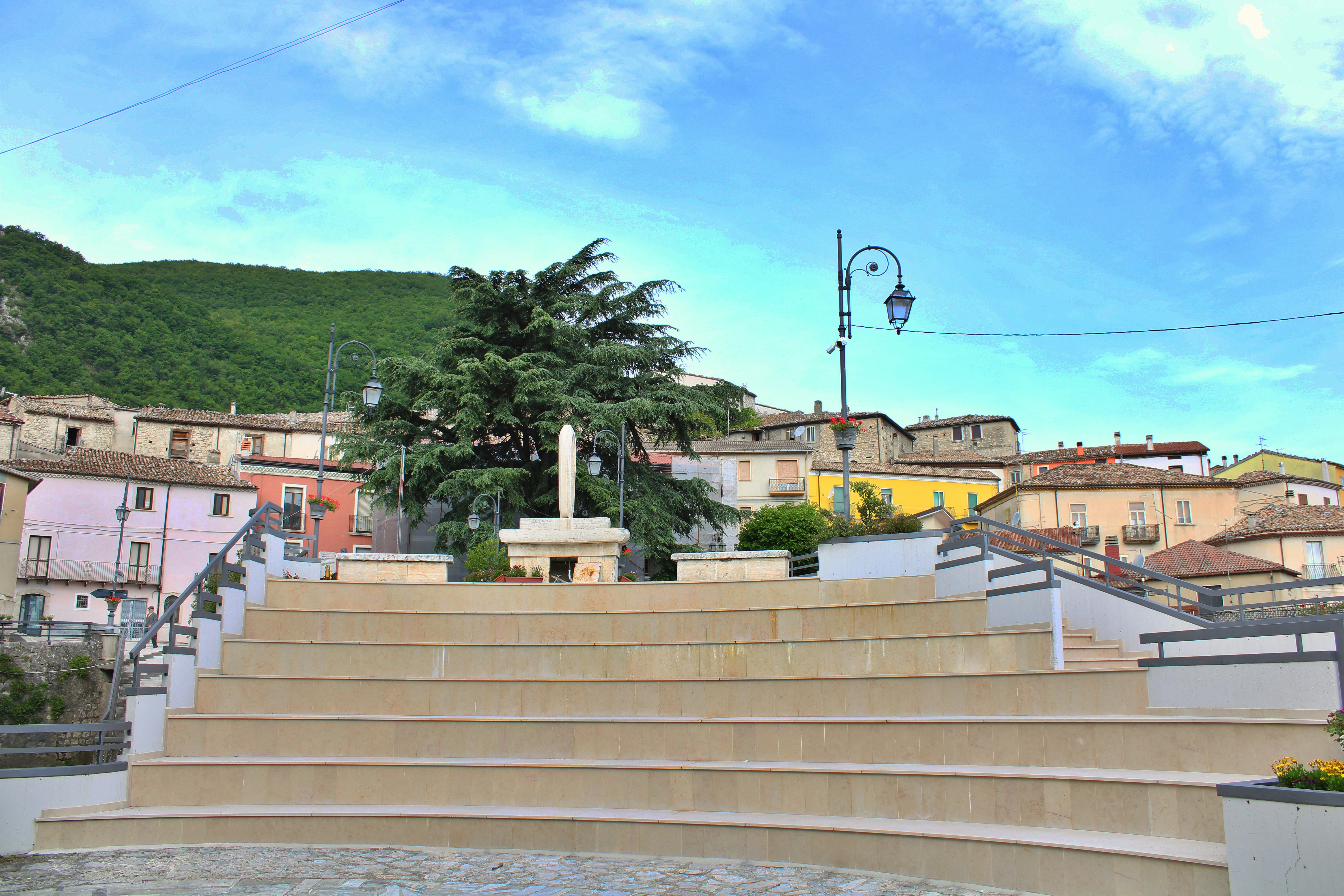 Terraced plaza with monument in a colorful village.