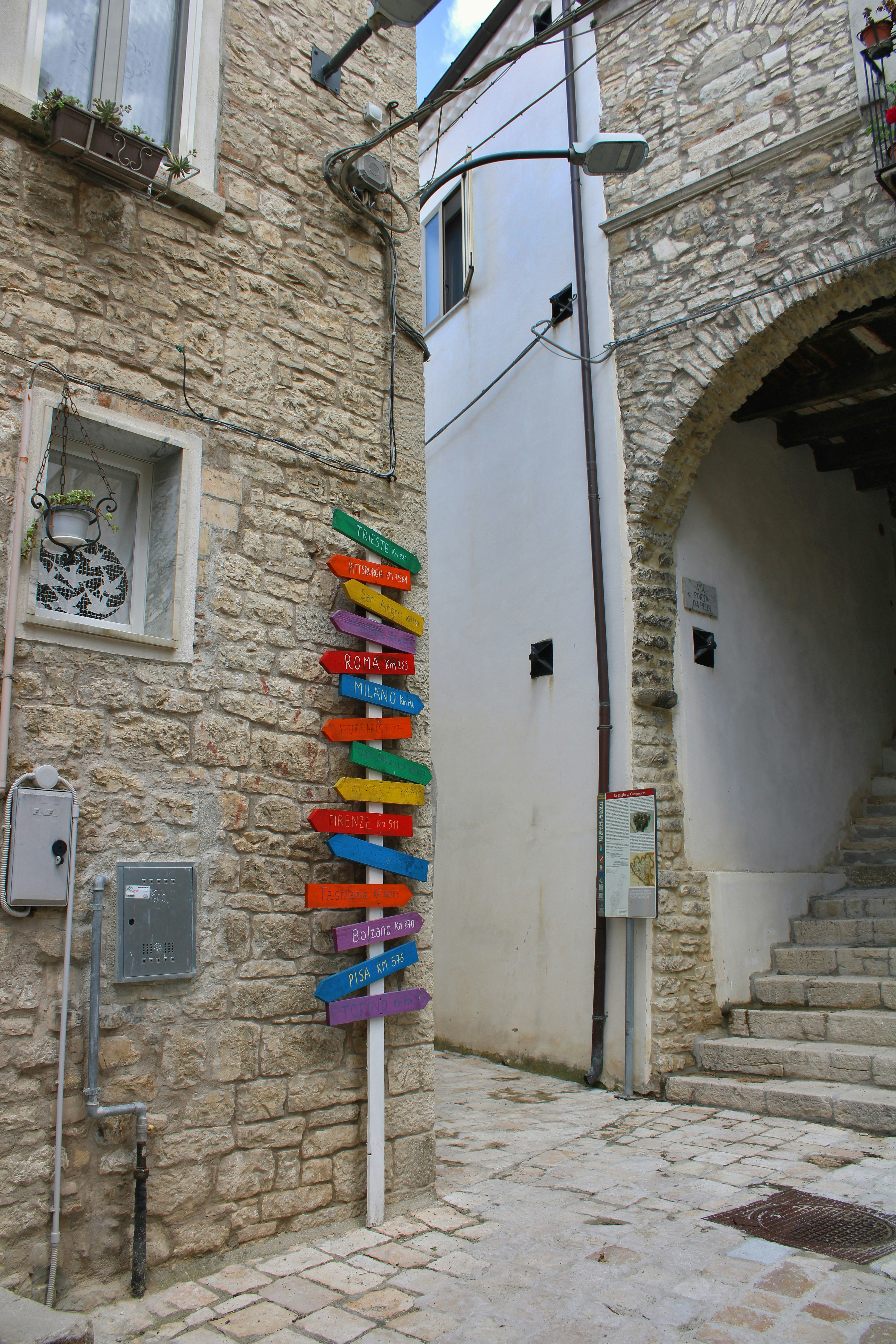 Colorful directional signs on a stone wall