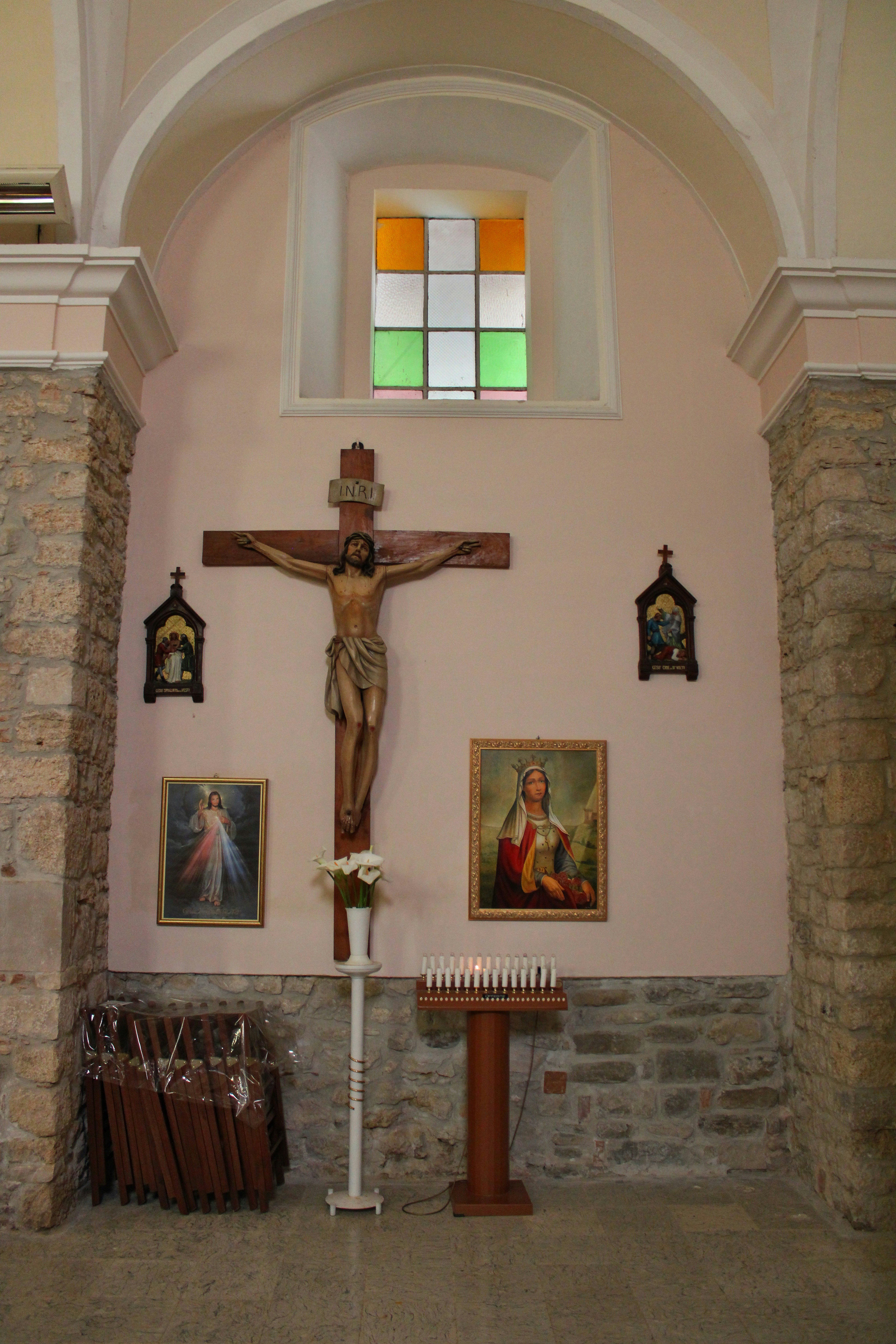 Jesus on the cross with candles and religious art.
