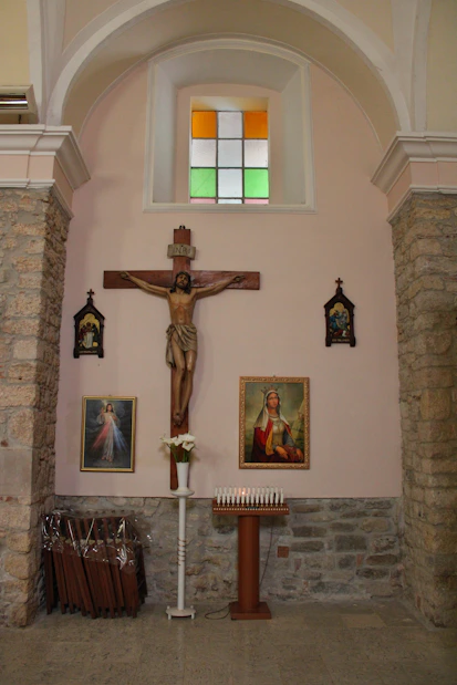 Jesus on the cross with candles and religious art.