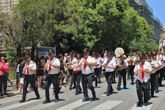 A marching band plays instruments during a parade.