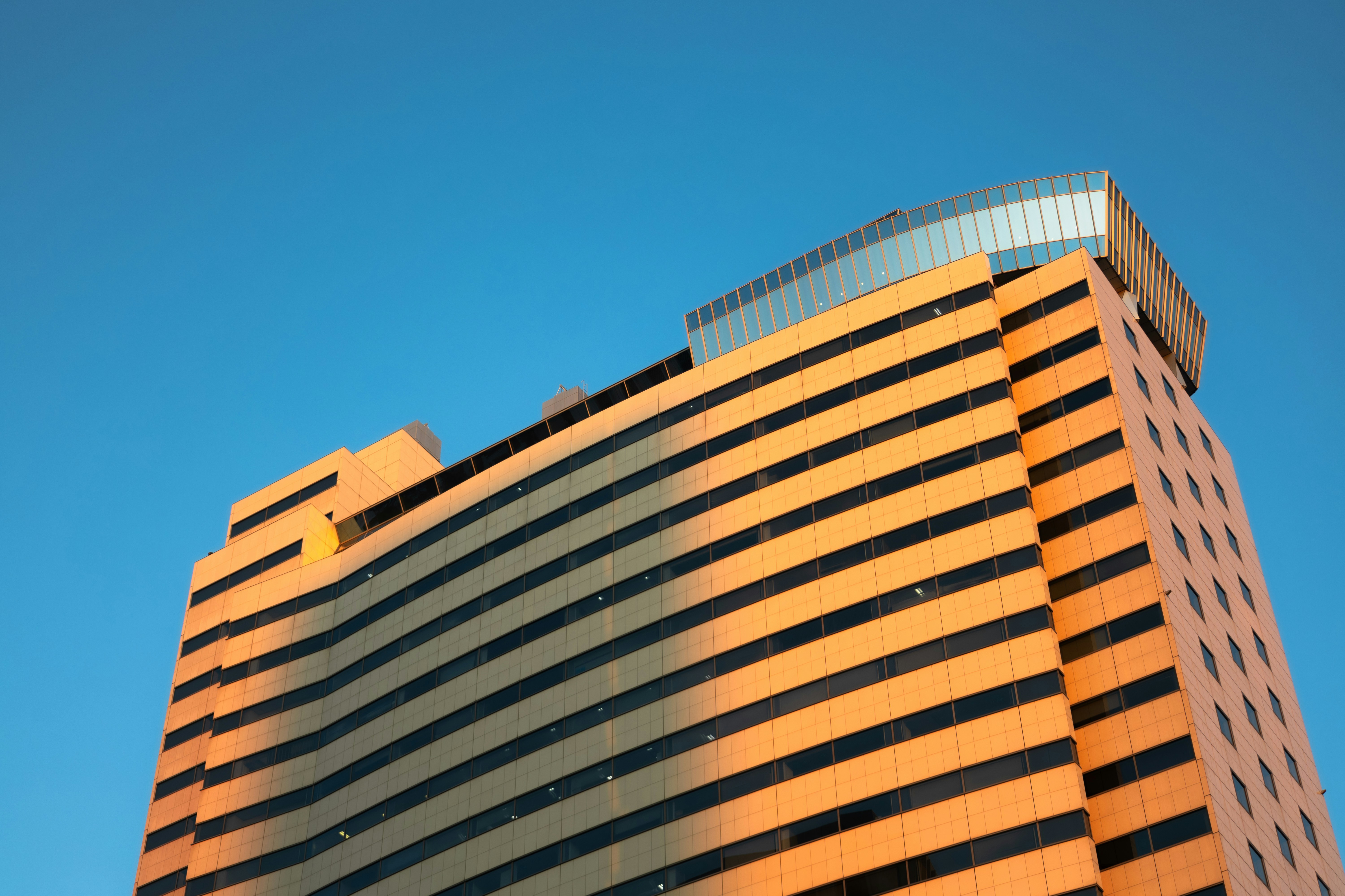 Modern building with striped facade against blue sky