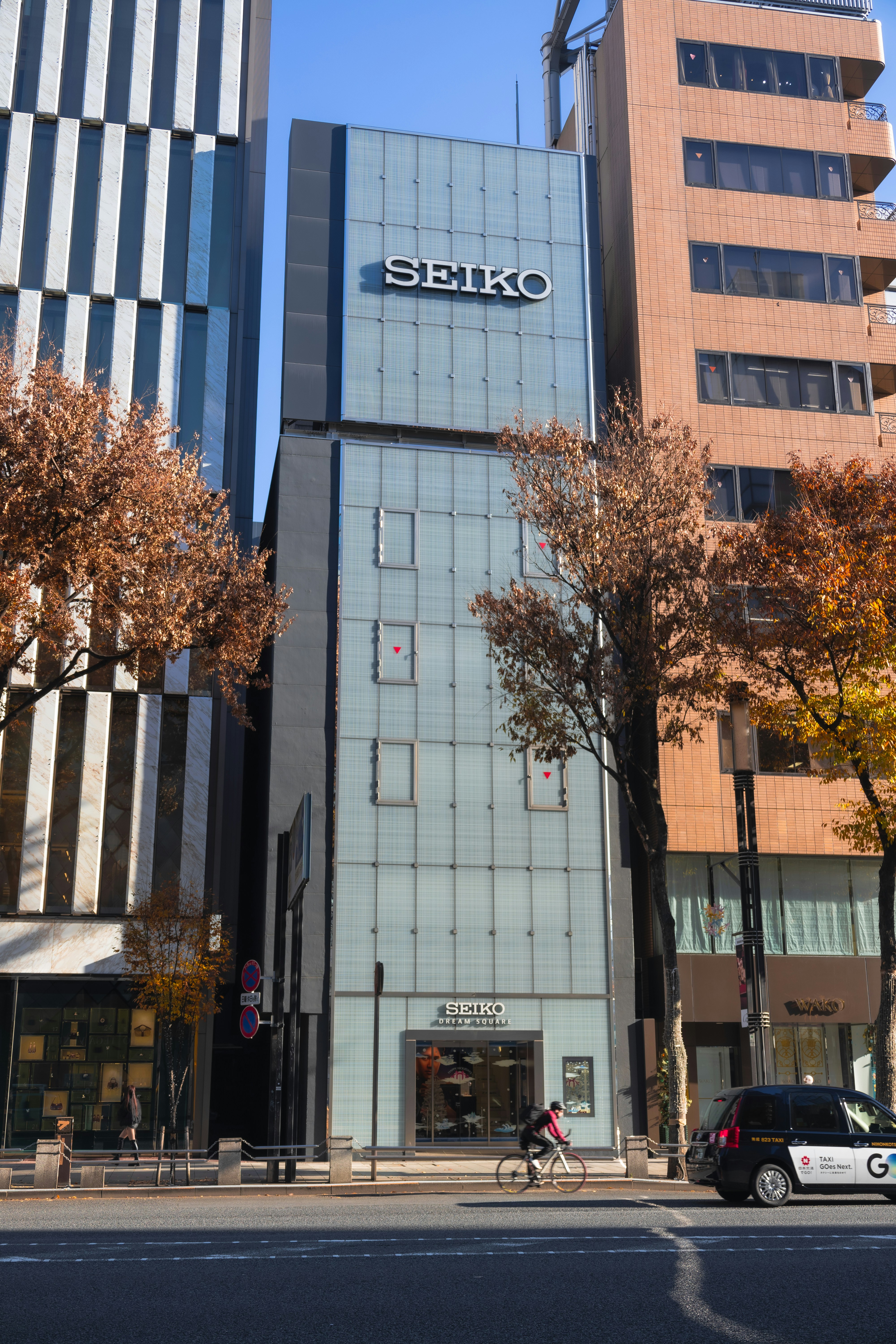 Seiko building on a city street with trees