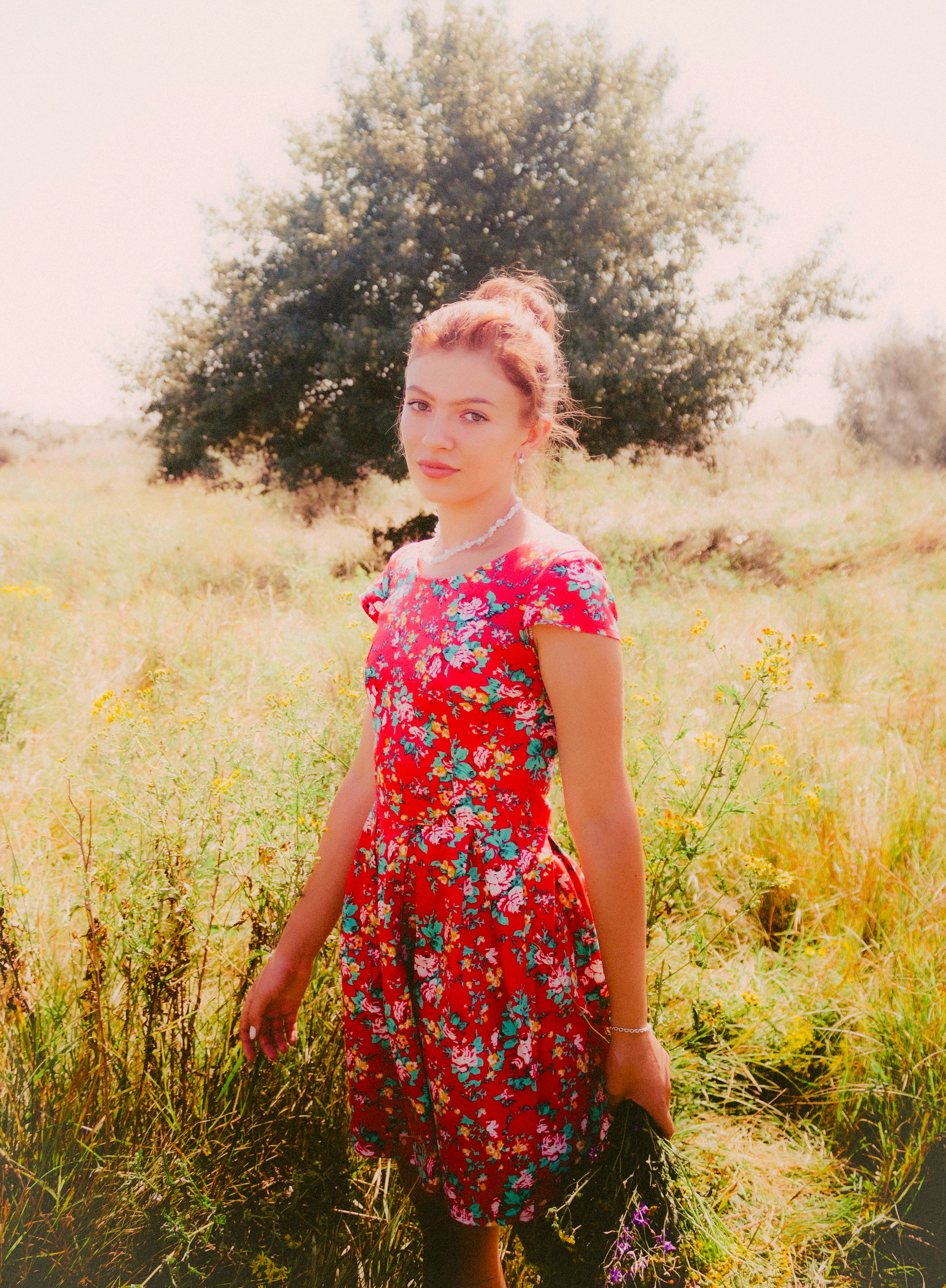 Young woman in a floral dress in a field.