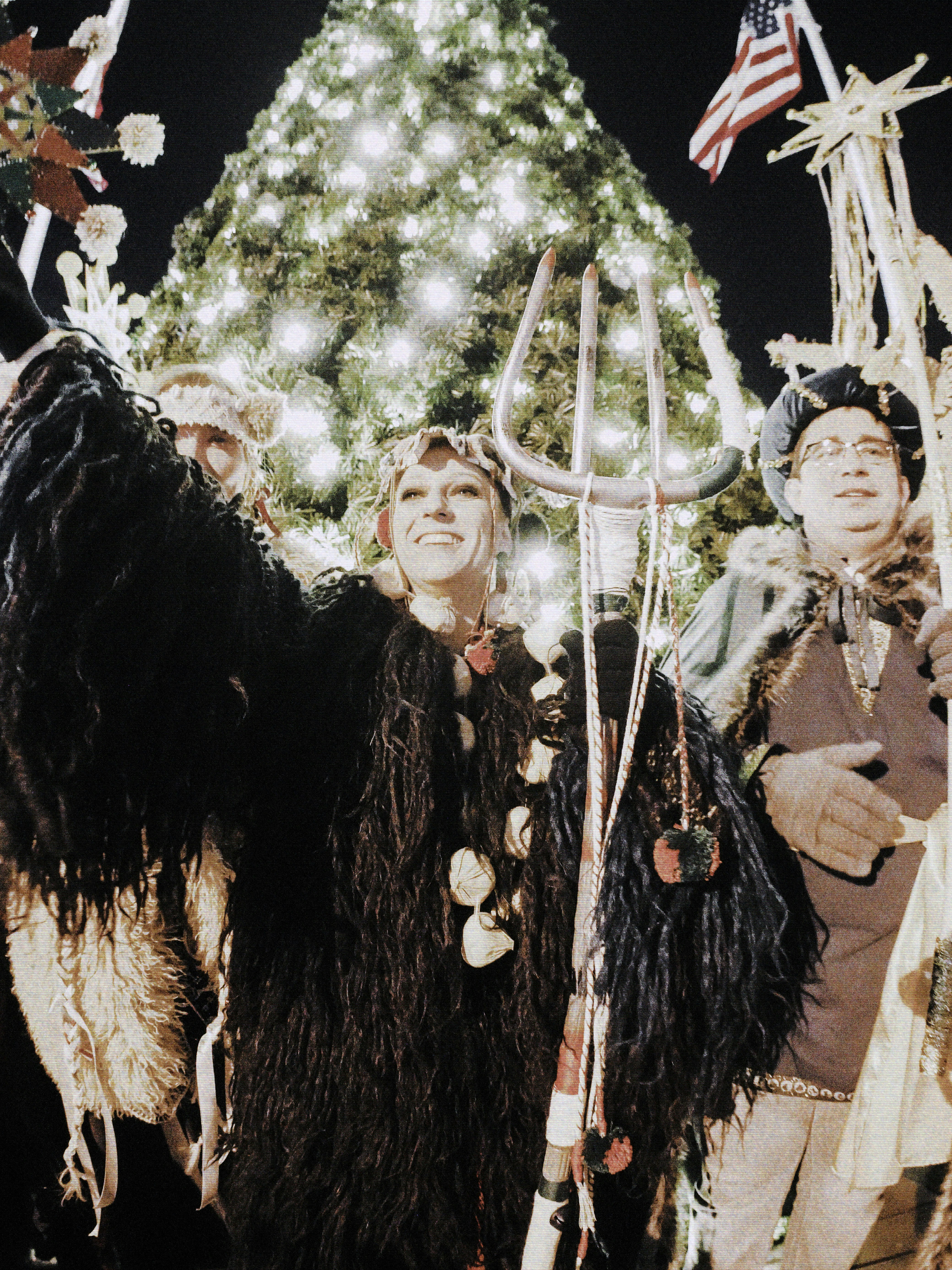 People in costumes with a christmas tree