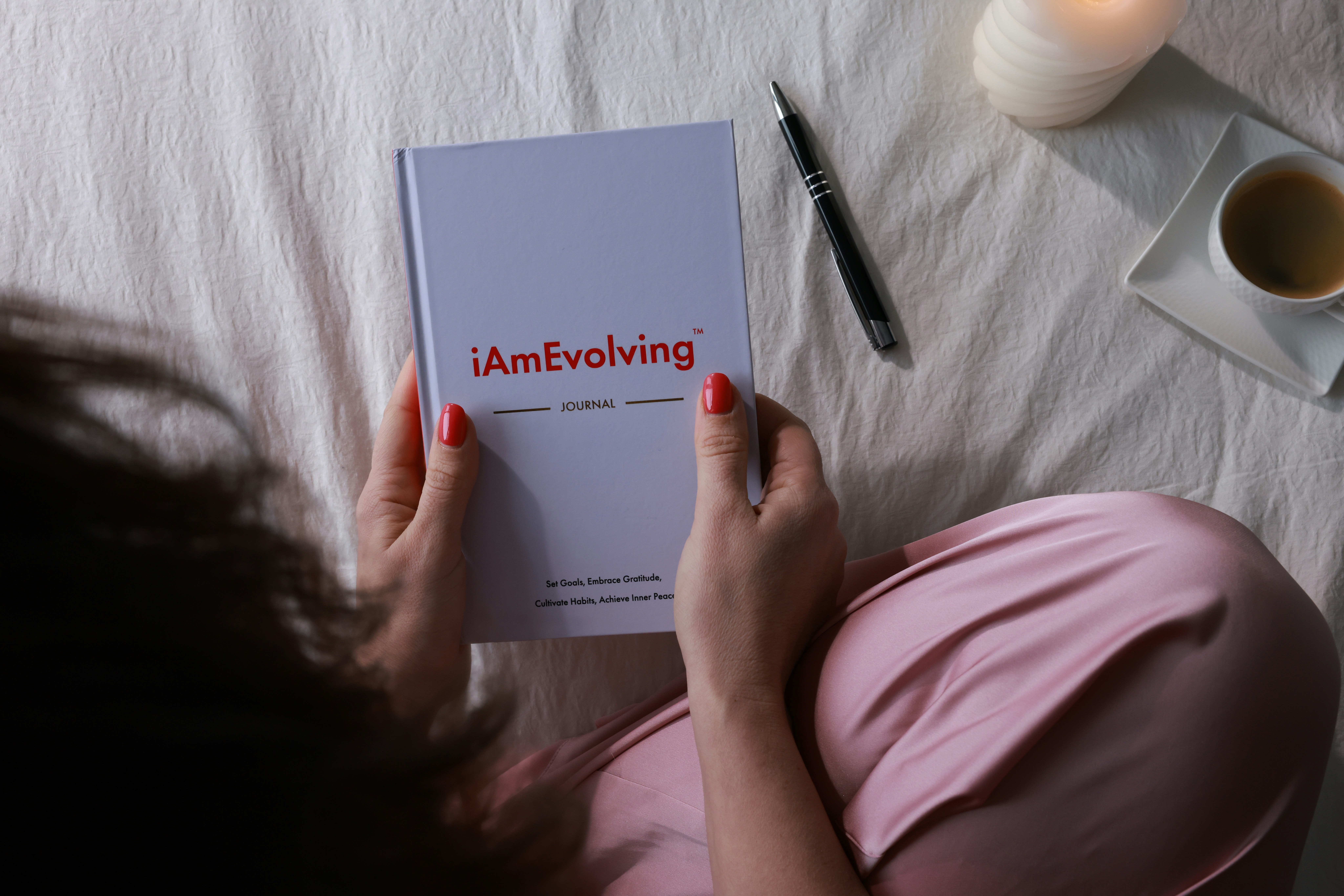 Woman reading a journal with a pen and coffee