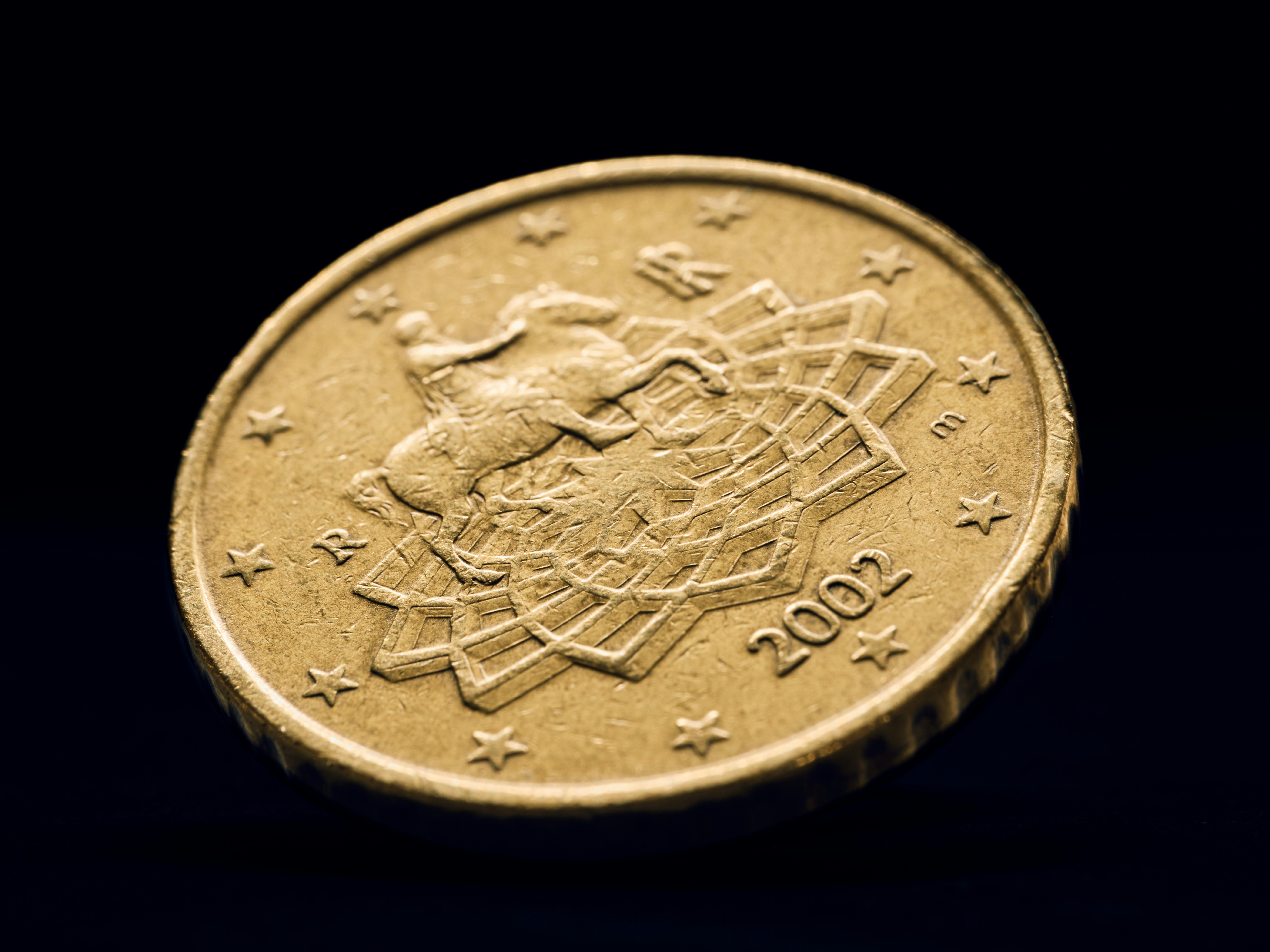 A close-up of a gold coin with 2002 on it