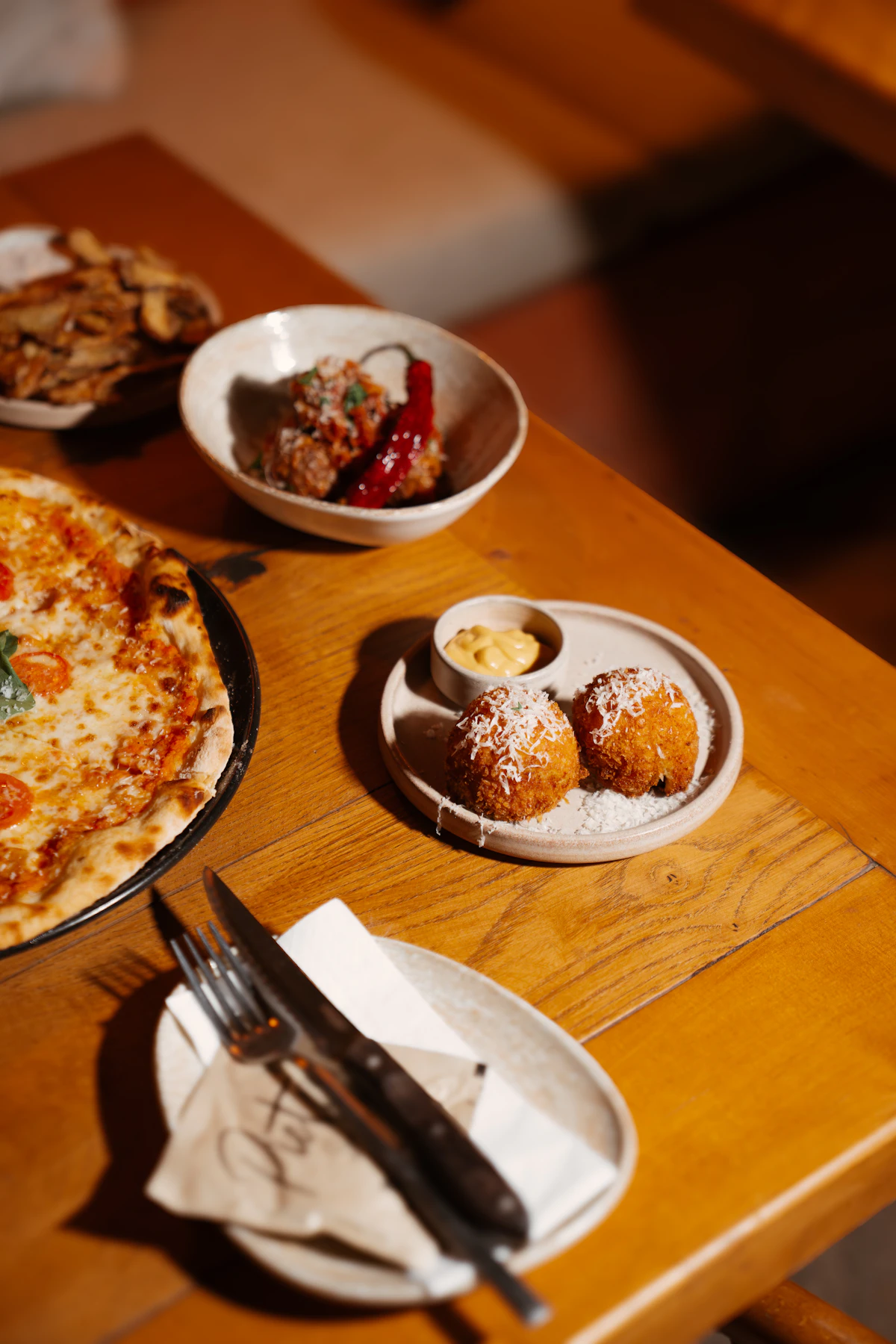 Pizza, Arancini und italienische Gerichte auf einem Holztisch