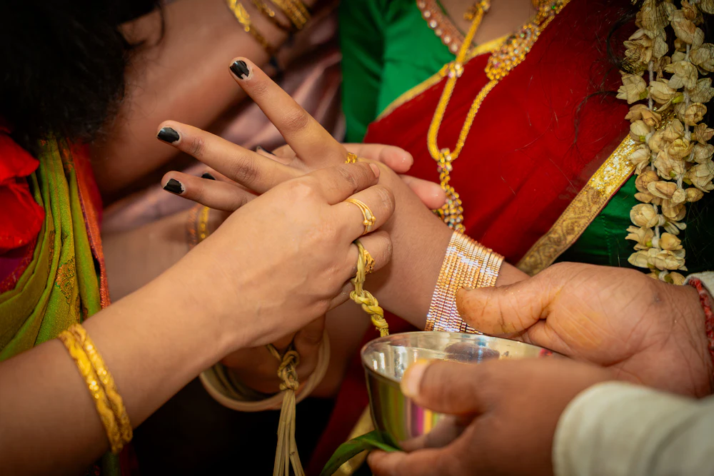 Hands tying a sacred thread during a traditional Hindu wedding ceremony