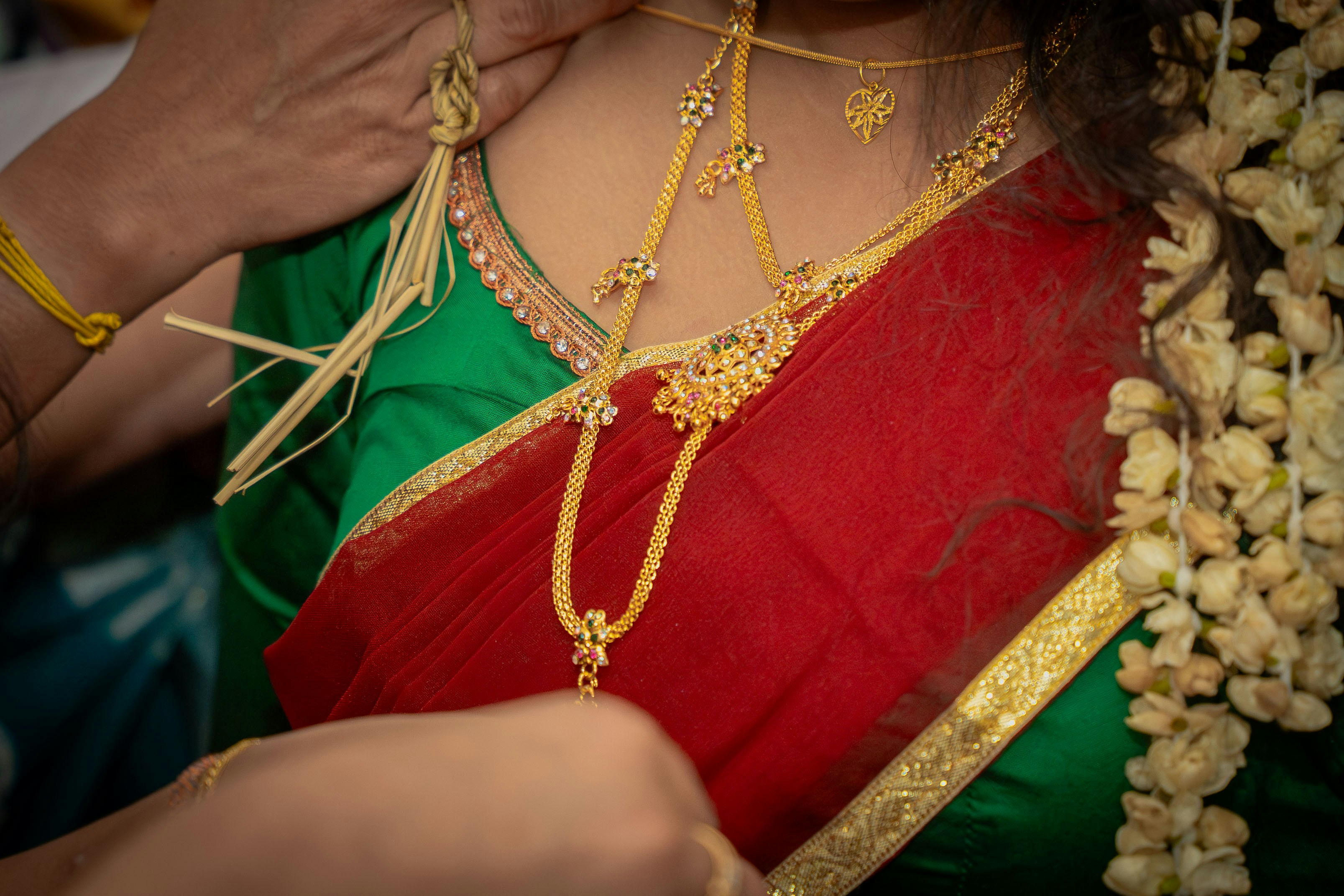 Woman wearing traditional indian gold jewelry and red saree