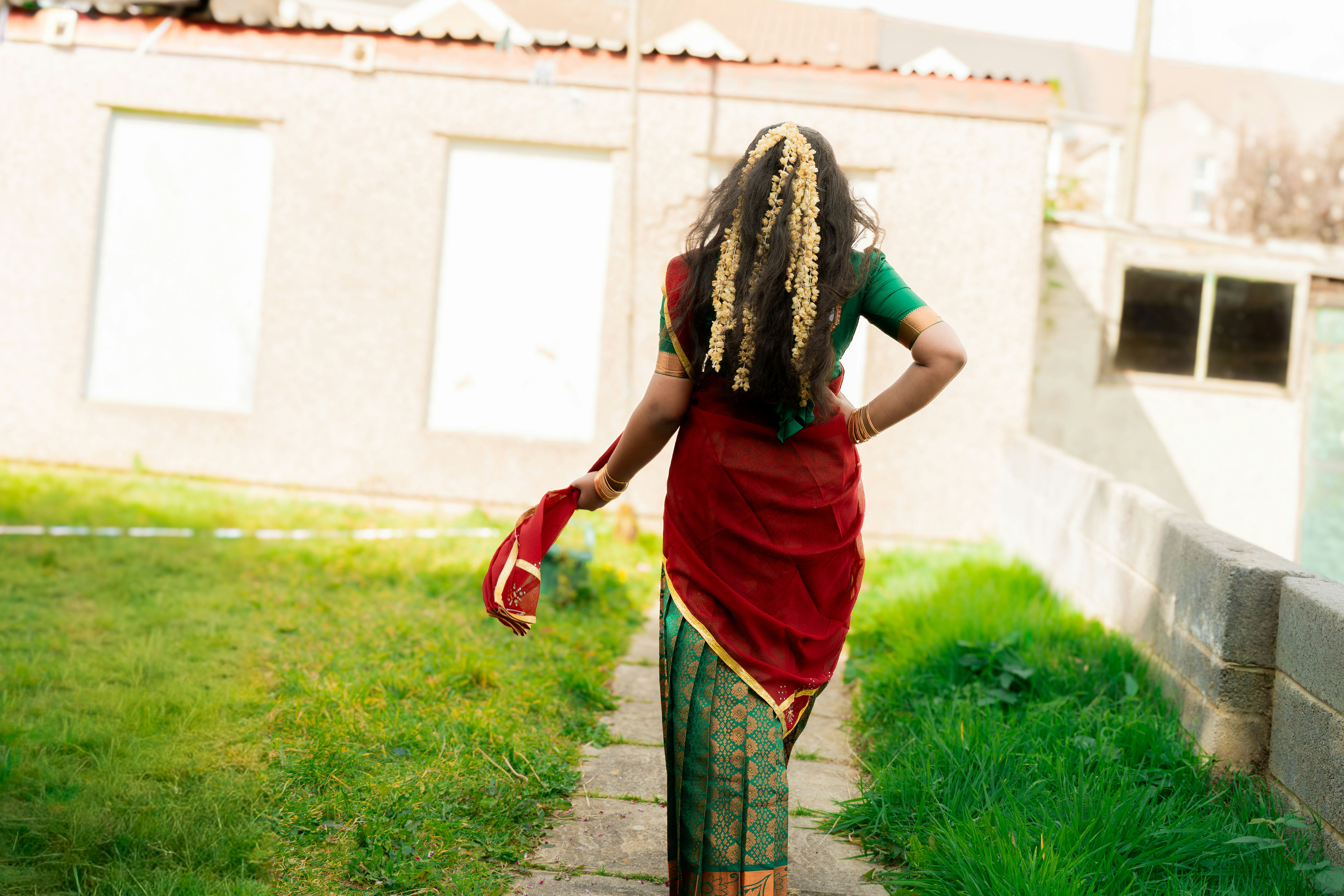 Woman in traditional indian attire walks away from camera.