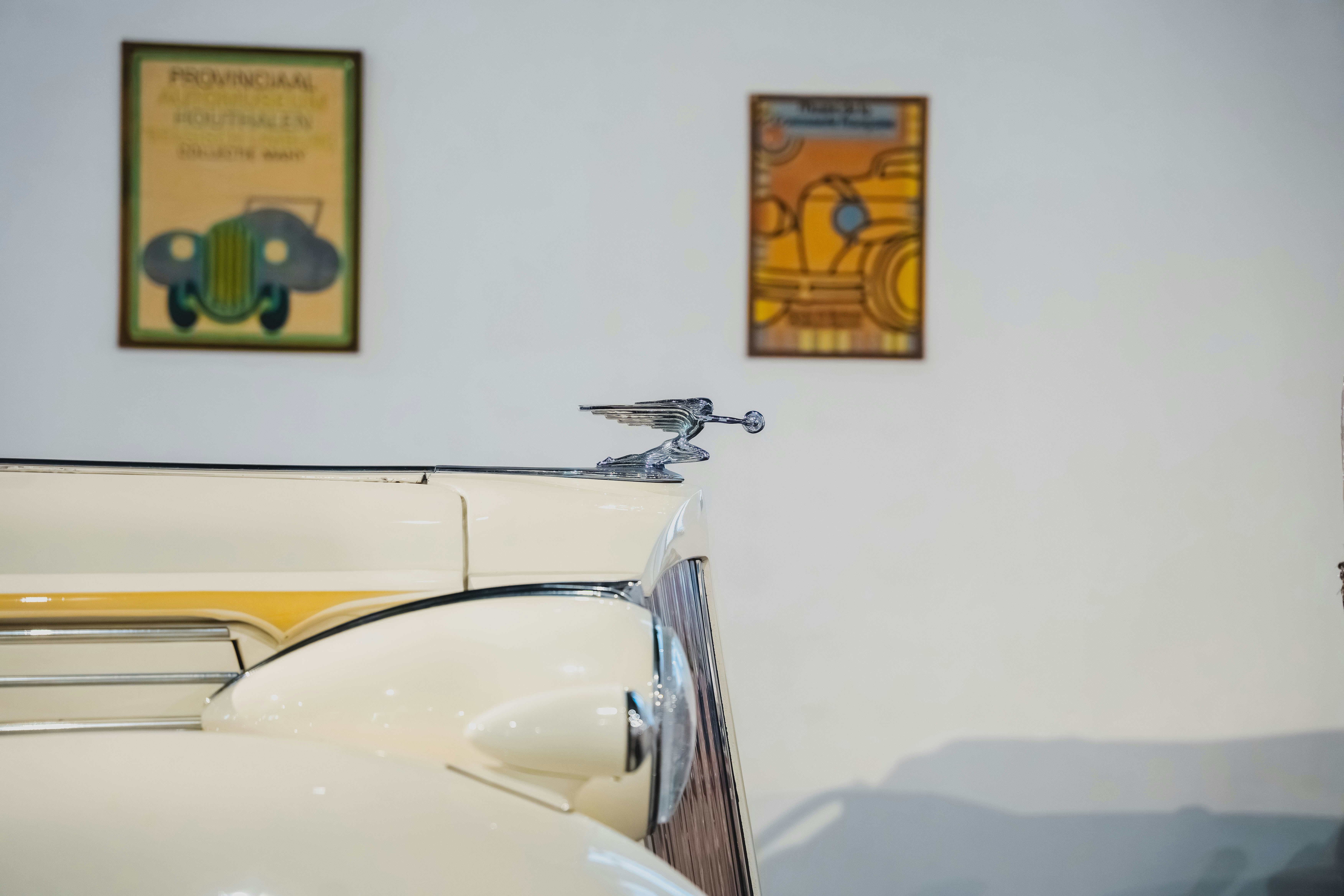 Vintage car hood ornament with artwork on wall