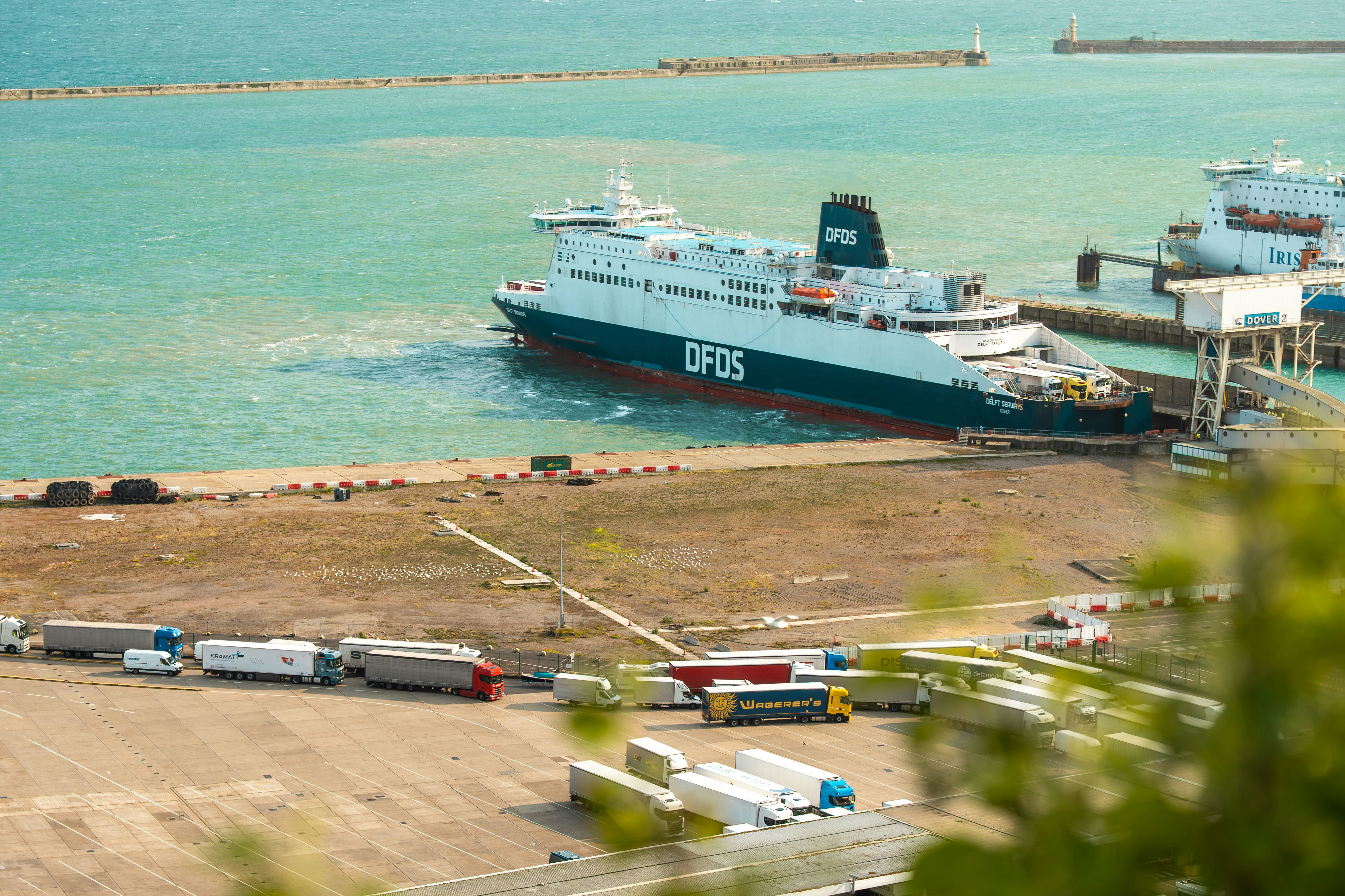 Large ferry docked at a port with trucks waiting
