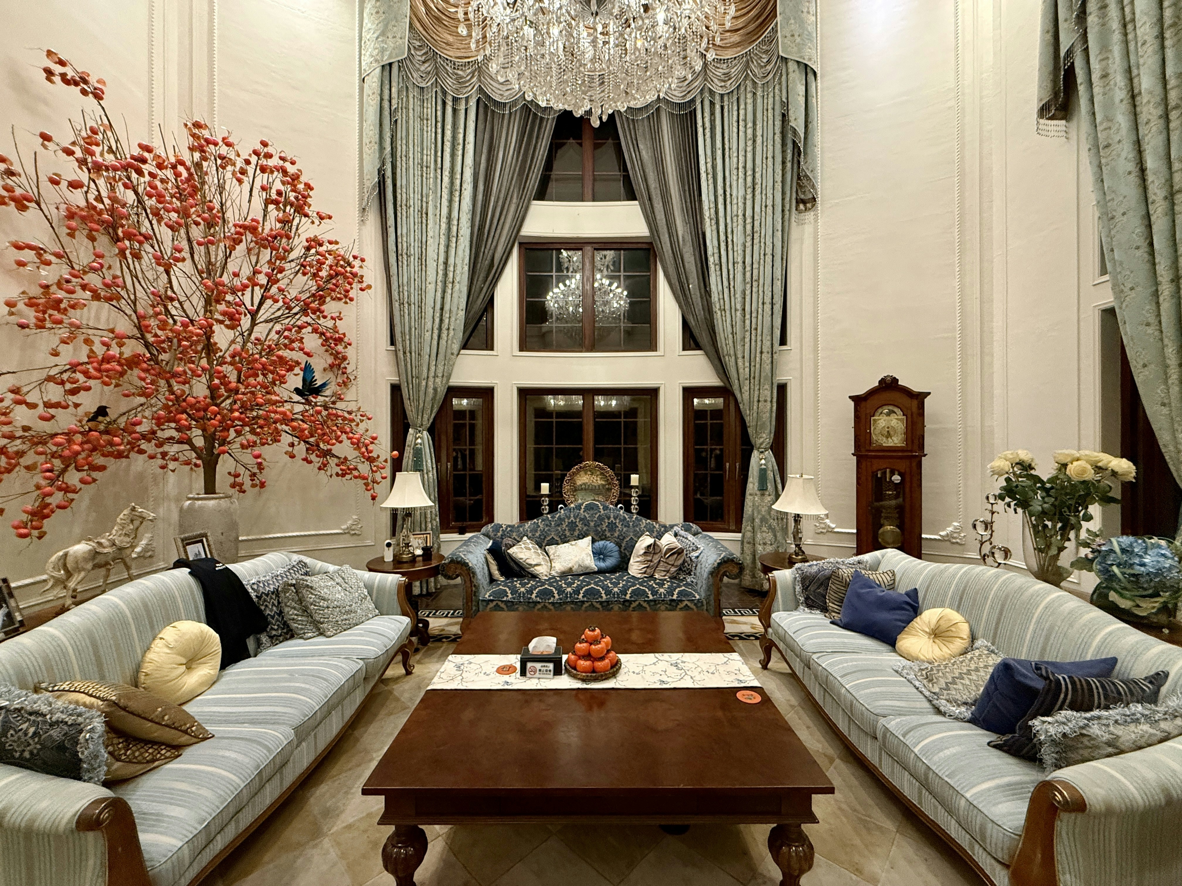 Elegant living room with ornate chandelier and seating.