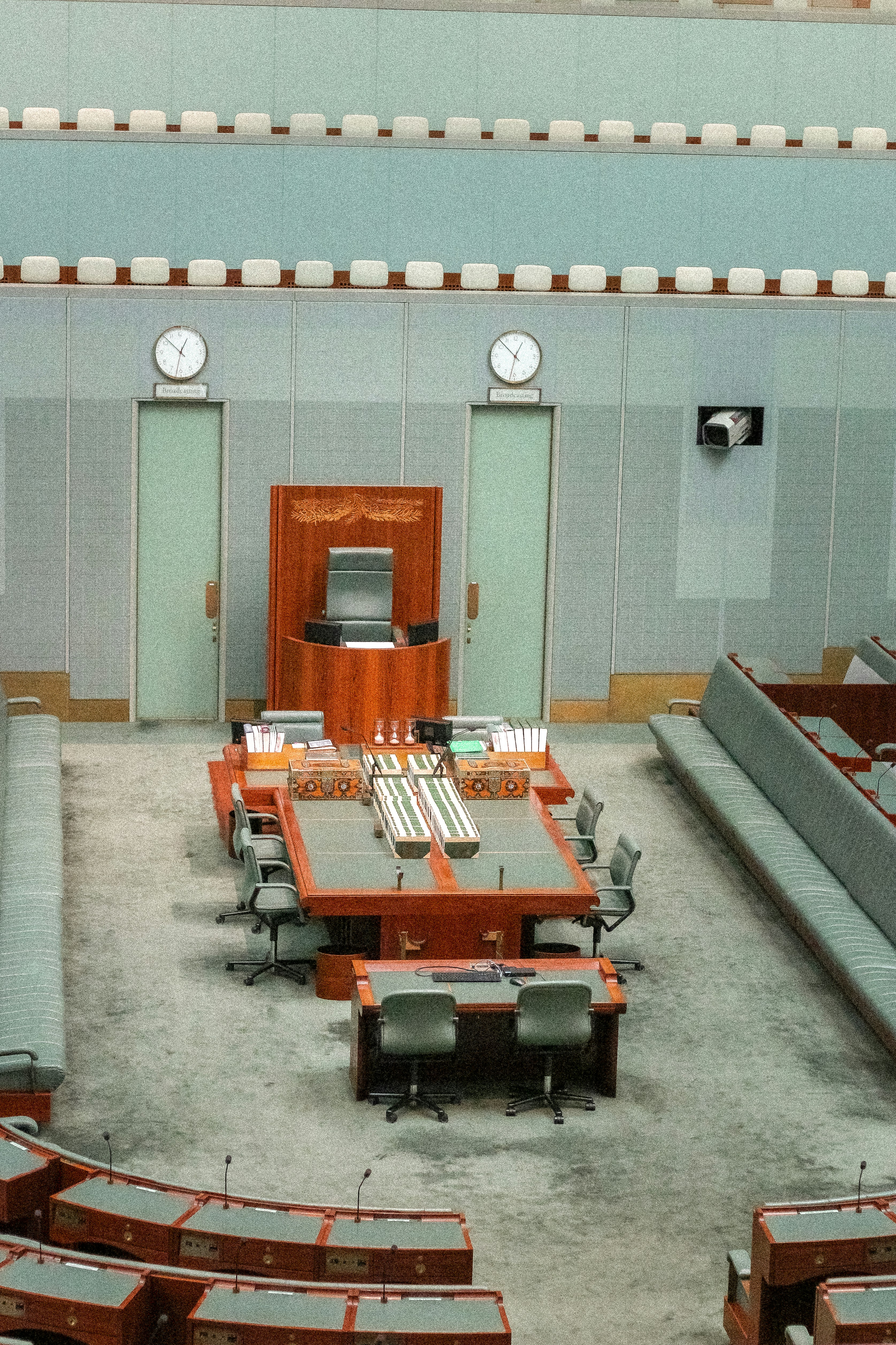 Cámara parlamentaria vacía con escritorios y asientos