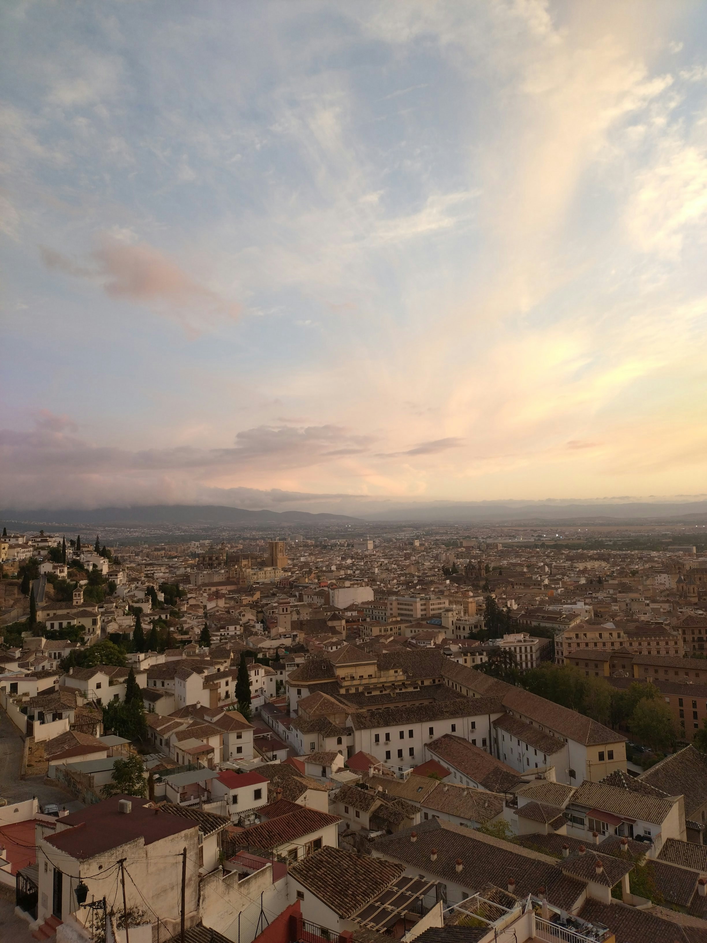 Cityscape with buildings and mountains at sunset