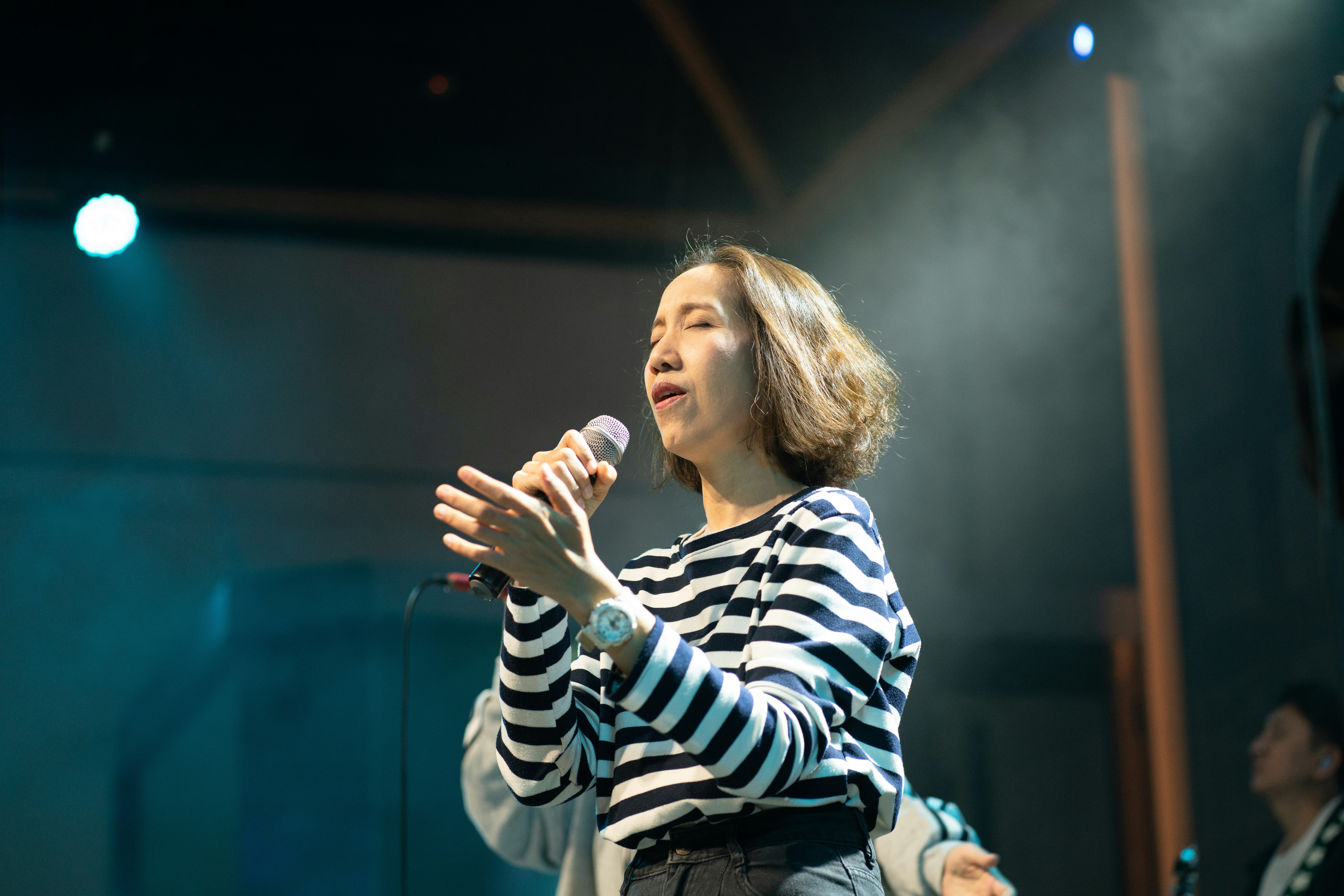 A woman singing into a microphone on stage