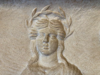 Carved relief of a woman wearing a laurel wreath.