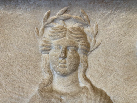 Carved relief of a woman wearing a laurel wreath.