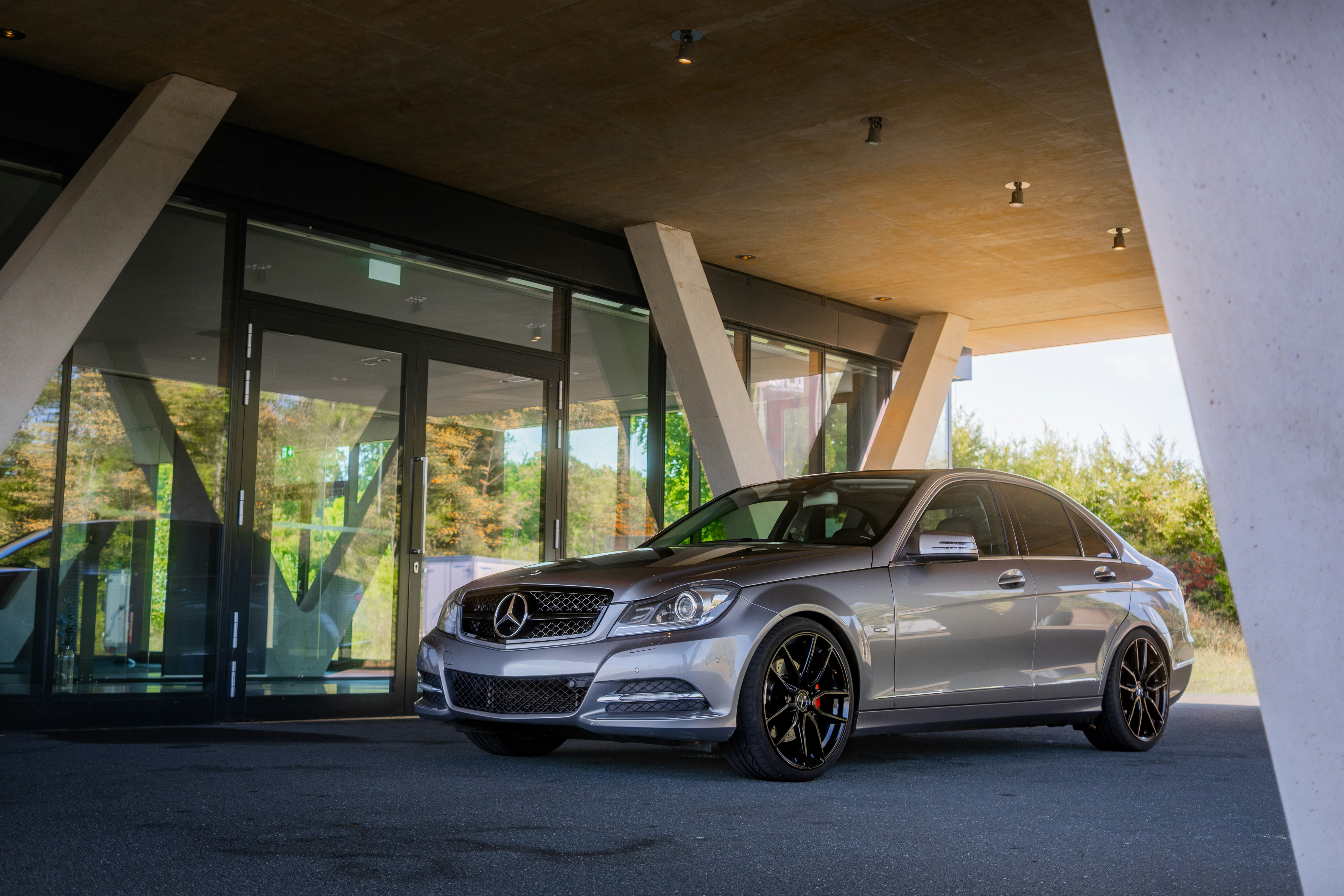 Silberner Mercedes-Benz vor dem modernen Gebäude geparkt