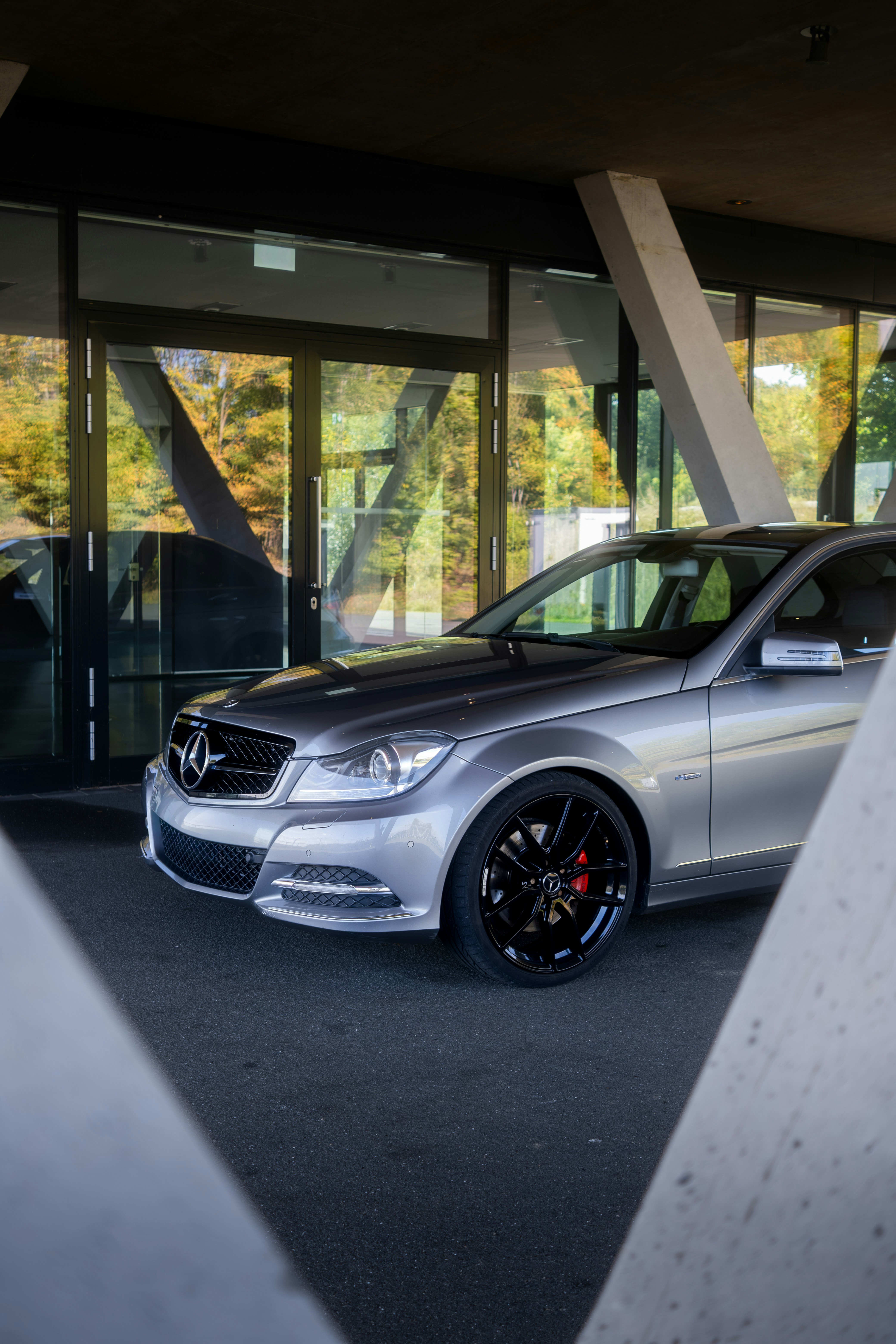 Silberner Mercedes-Benz vor dem modernen Gebäude geparkt
