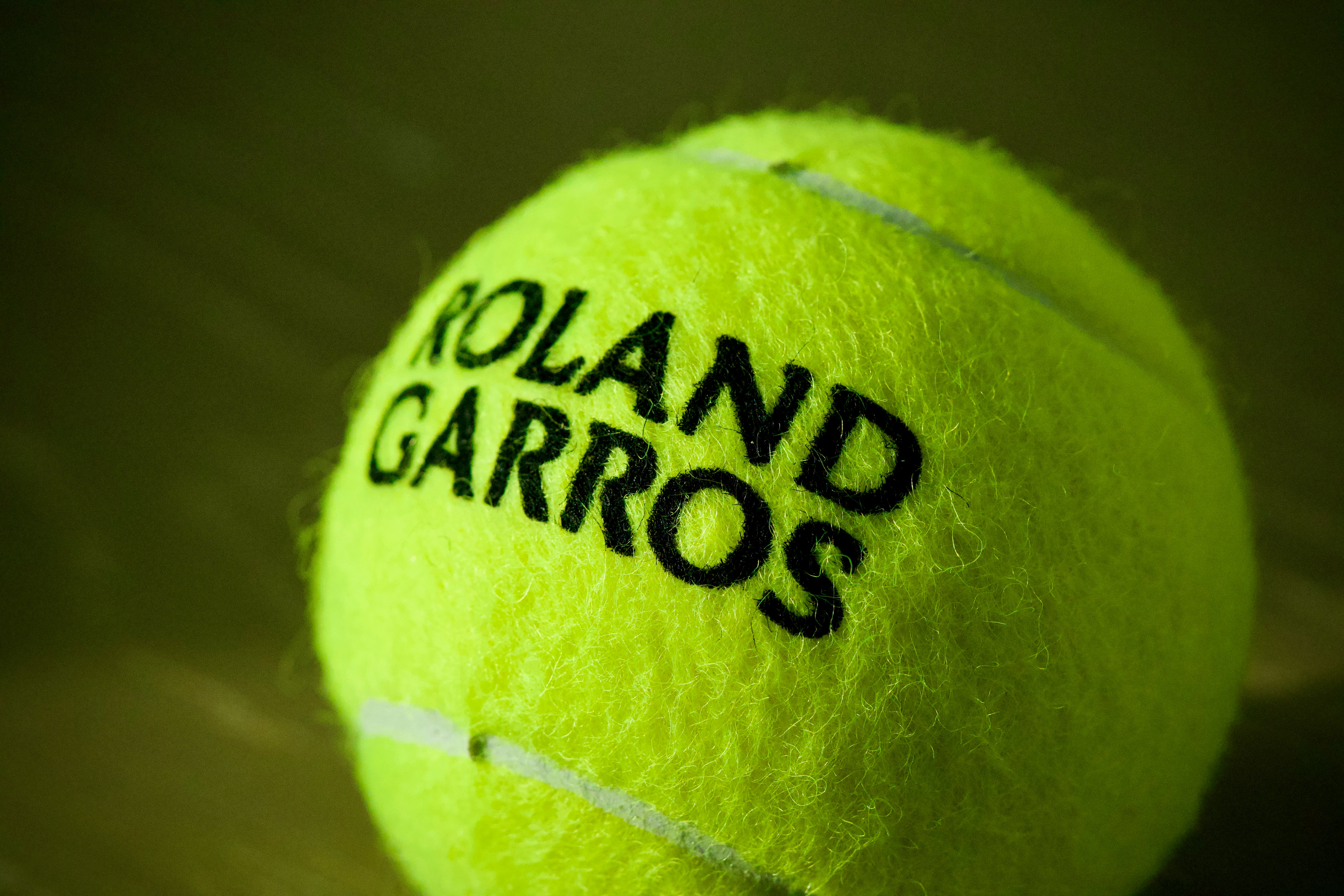 Partido de tenis en cancha de arcilla durante la noche