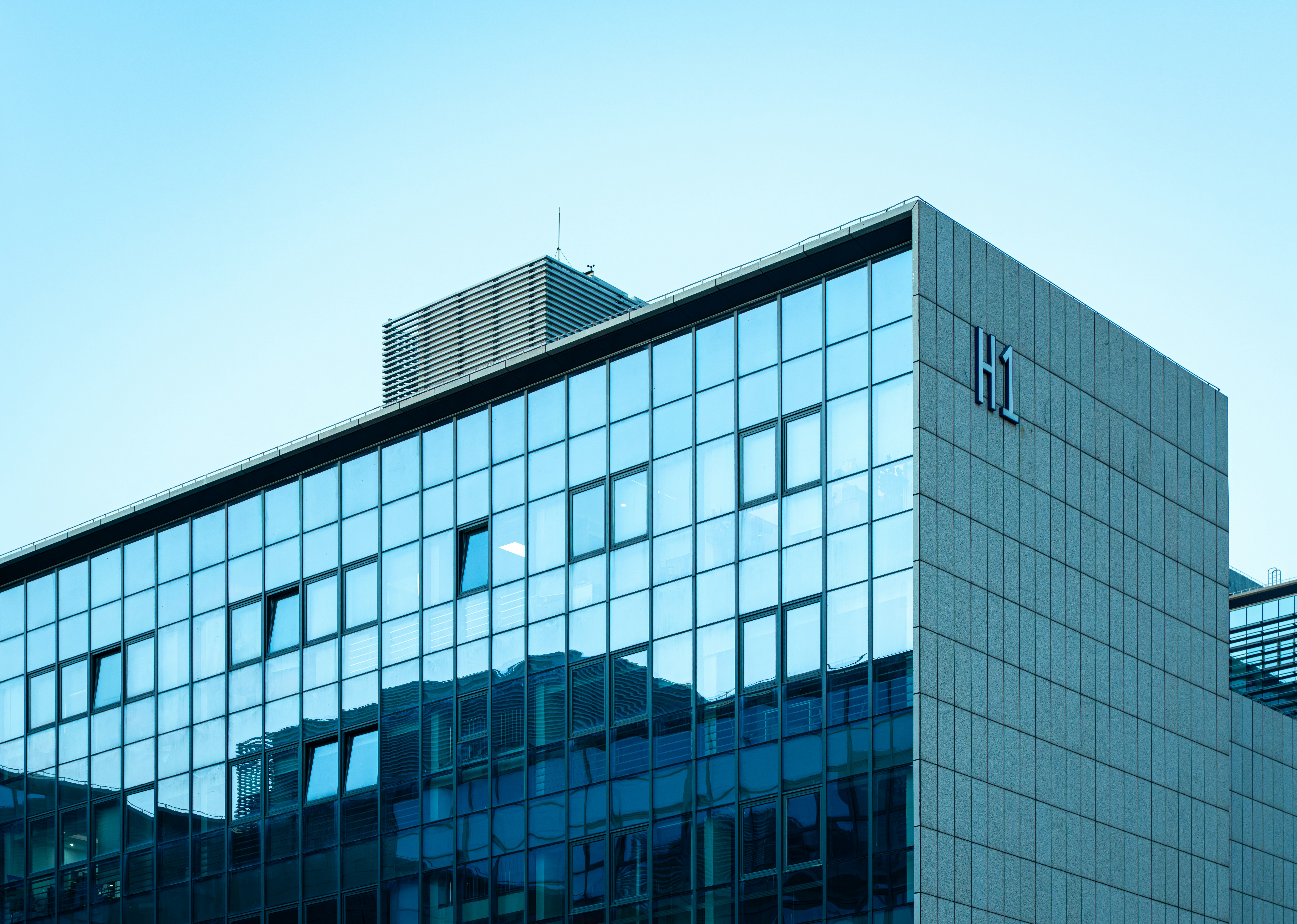 Modernes Glasgebäude spiegelt den klaren Himmel wider