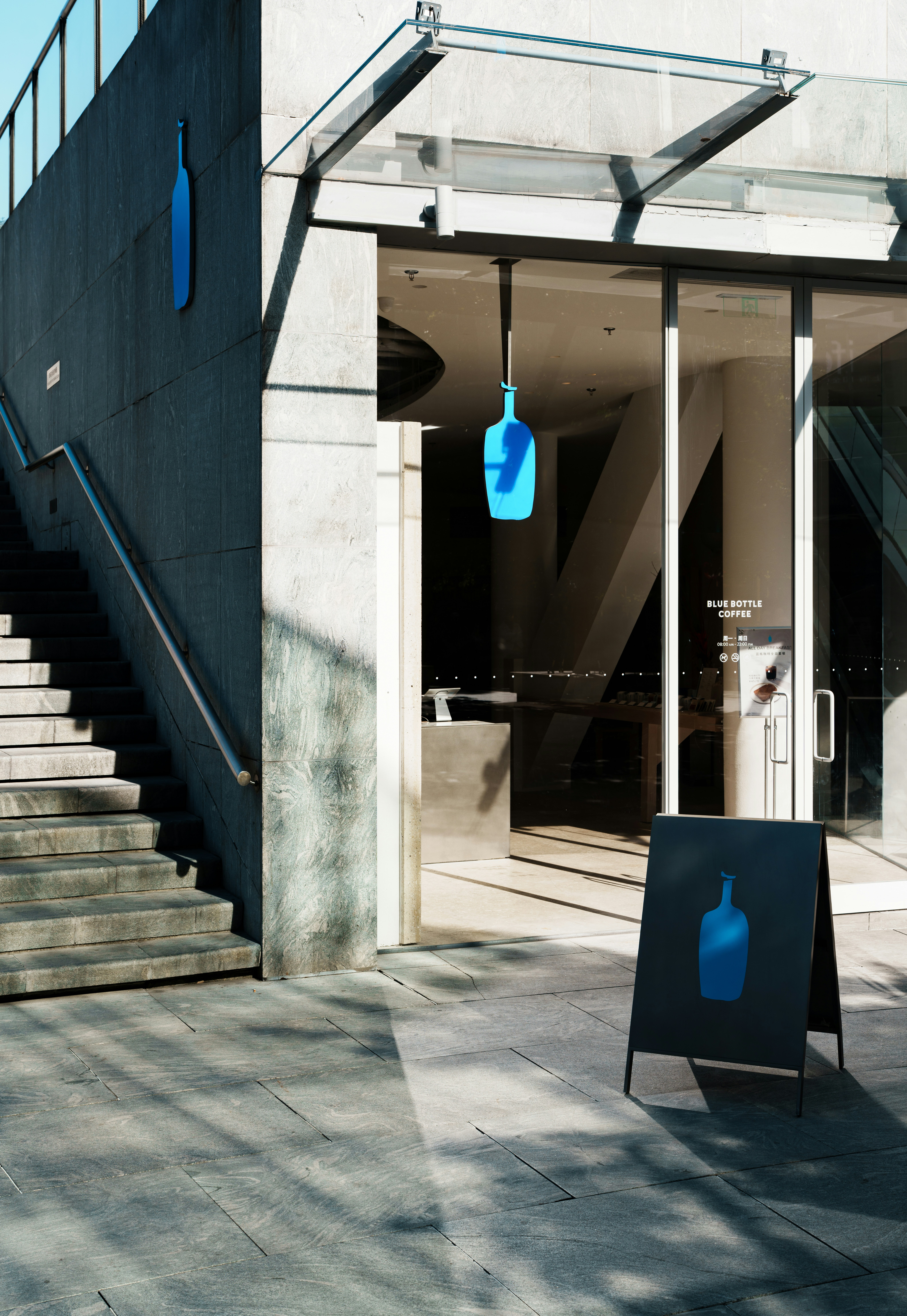 Eingang des modernen Gebäudes mit blauem Flaschenlogo