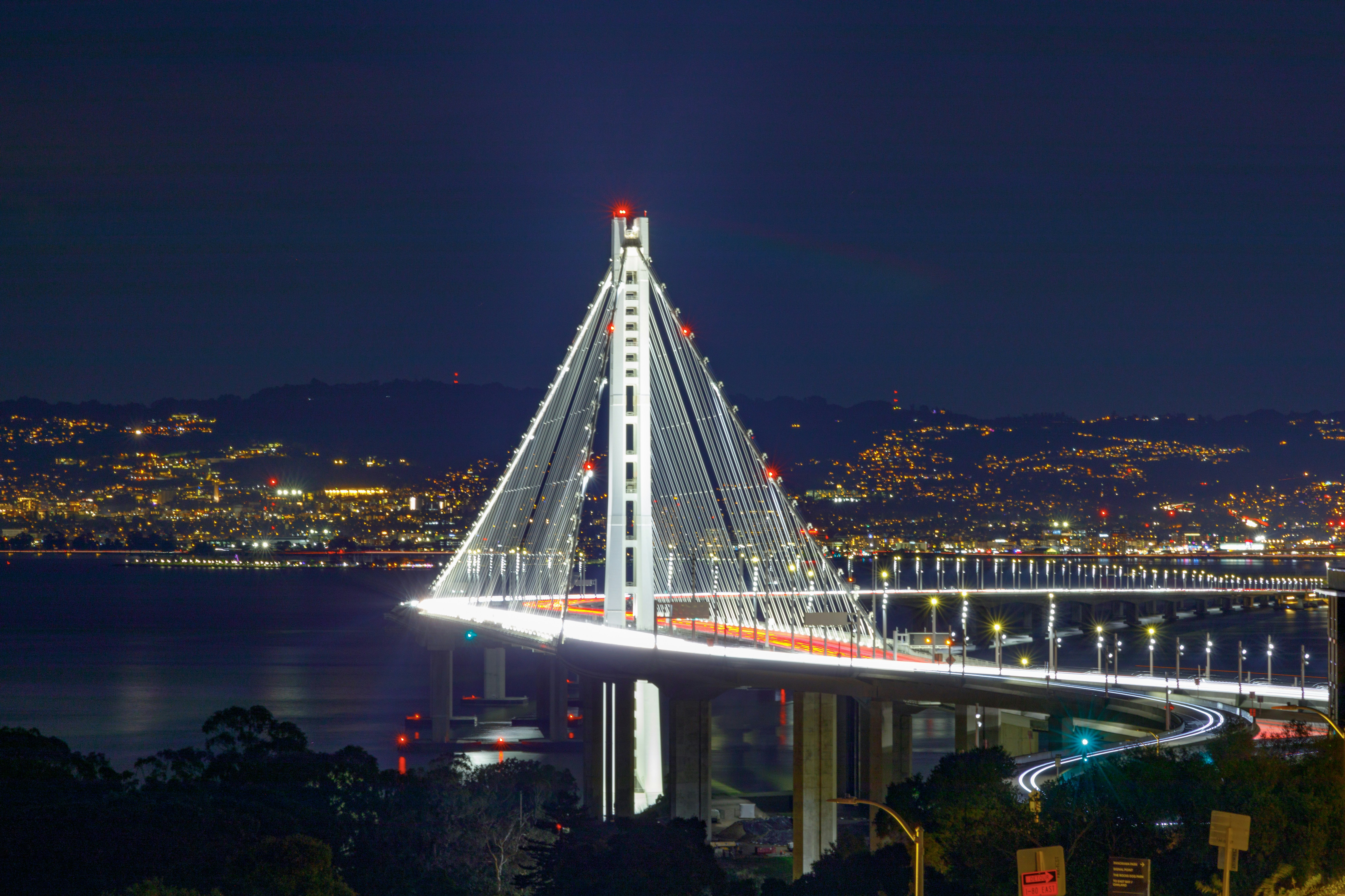 Ponte sospeso illuminato con luci cittadine di notte