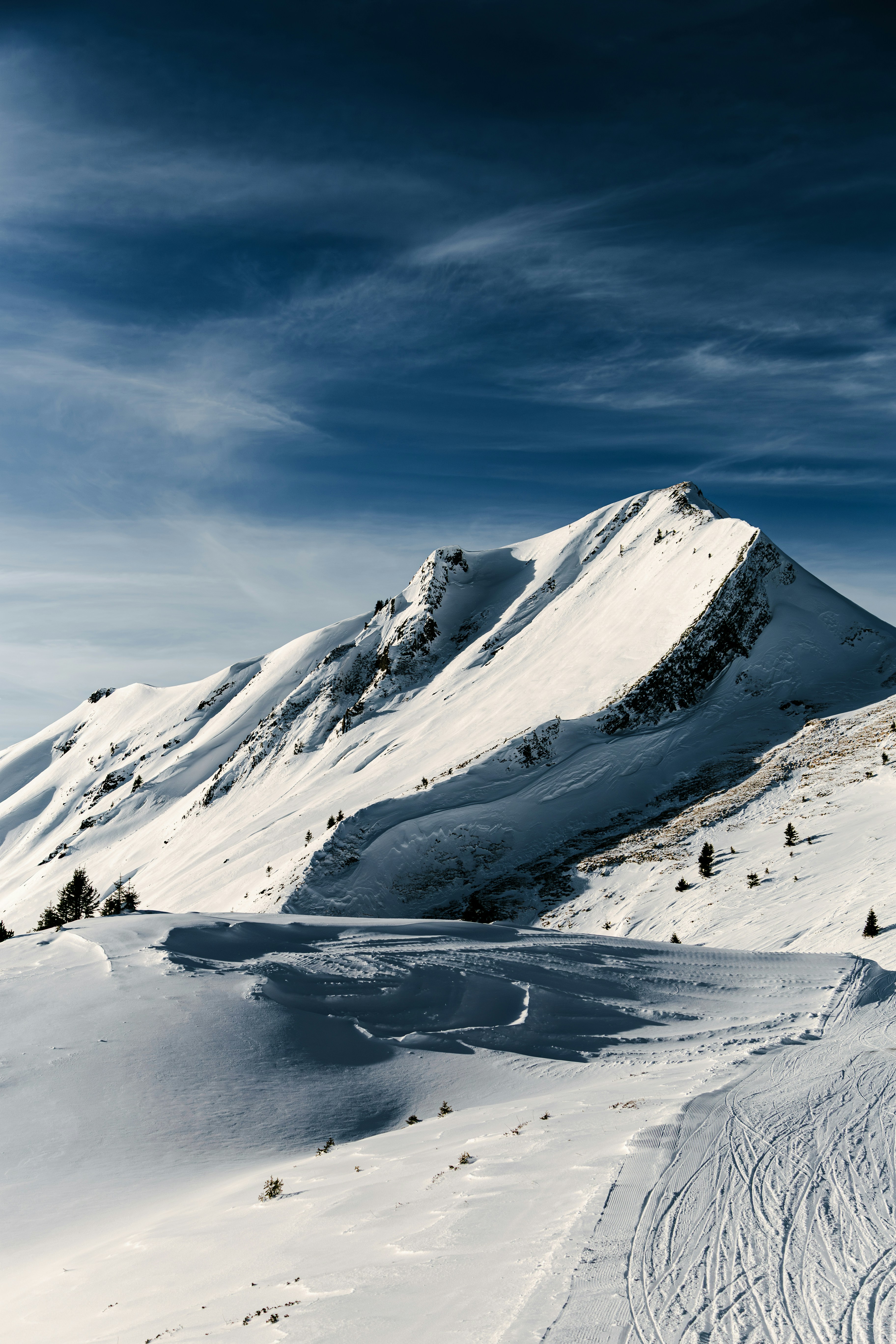 Snow-covered mountain range under a blue sky