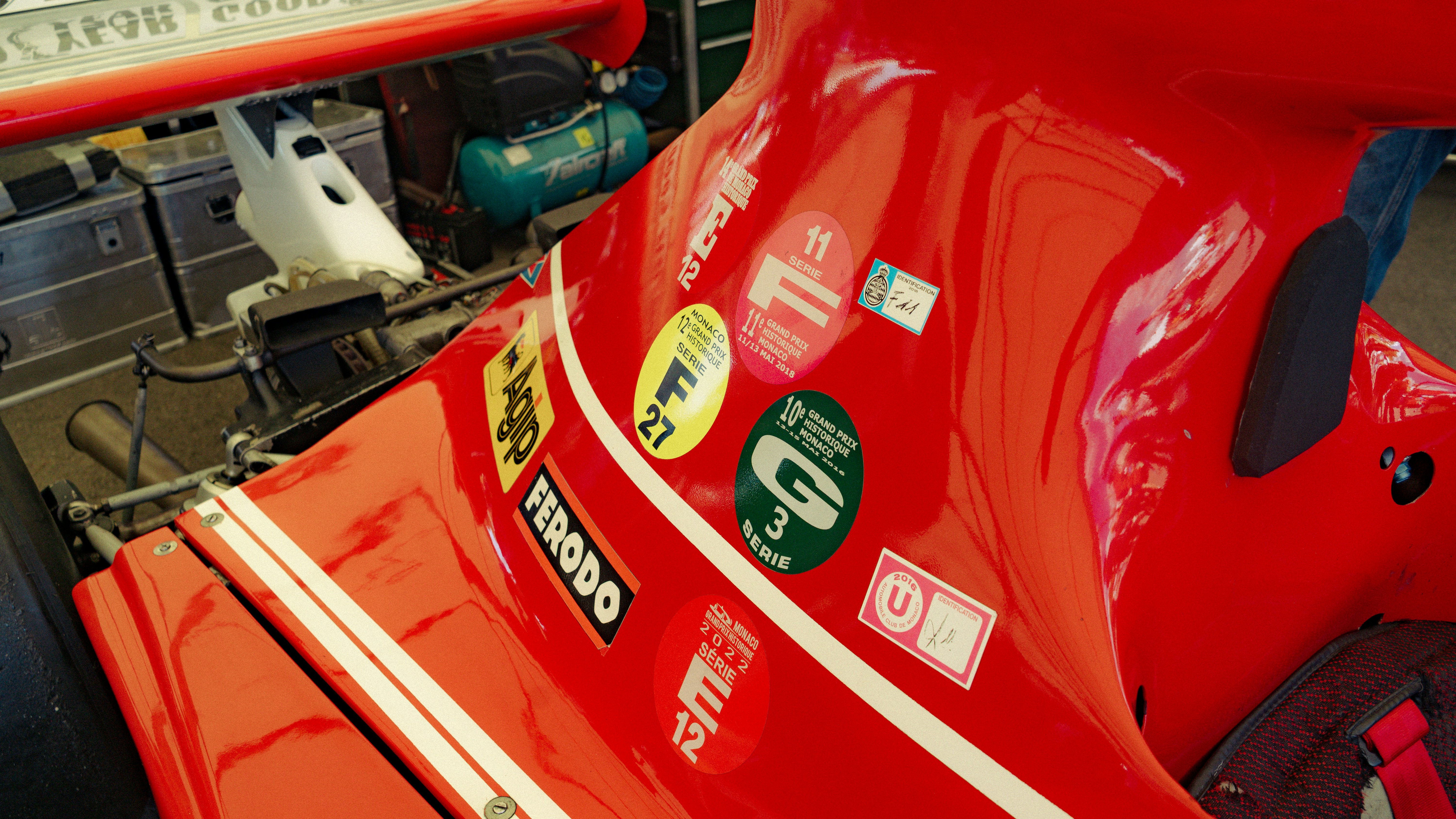 Red race car with sponsor stickers in workshop